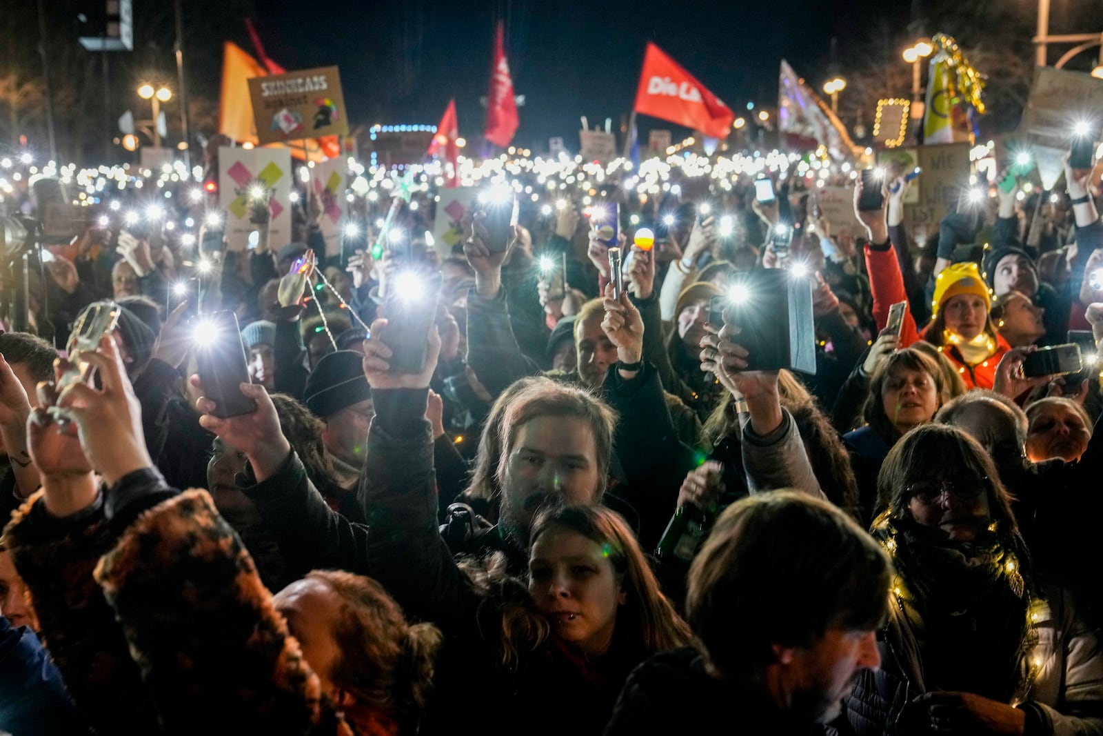 FILE - People hold up their cell phones as they protest against the far-right Alternative for Germany, or AfD party, and right-wing extremism in front of the Brandenburg Gate in Berlin, Germany, Jan. 25, 2025. (AP Photo/Ebrahim Noroozi, File)