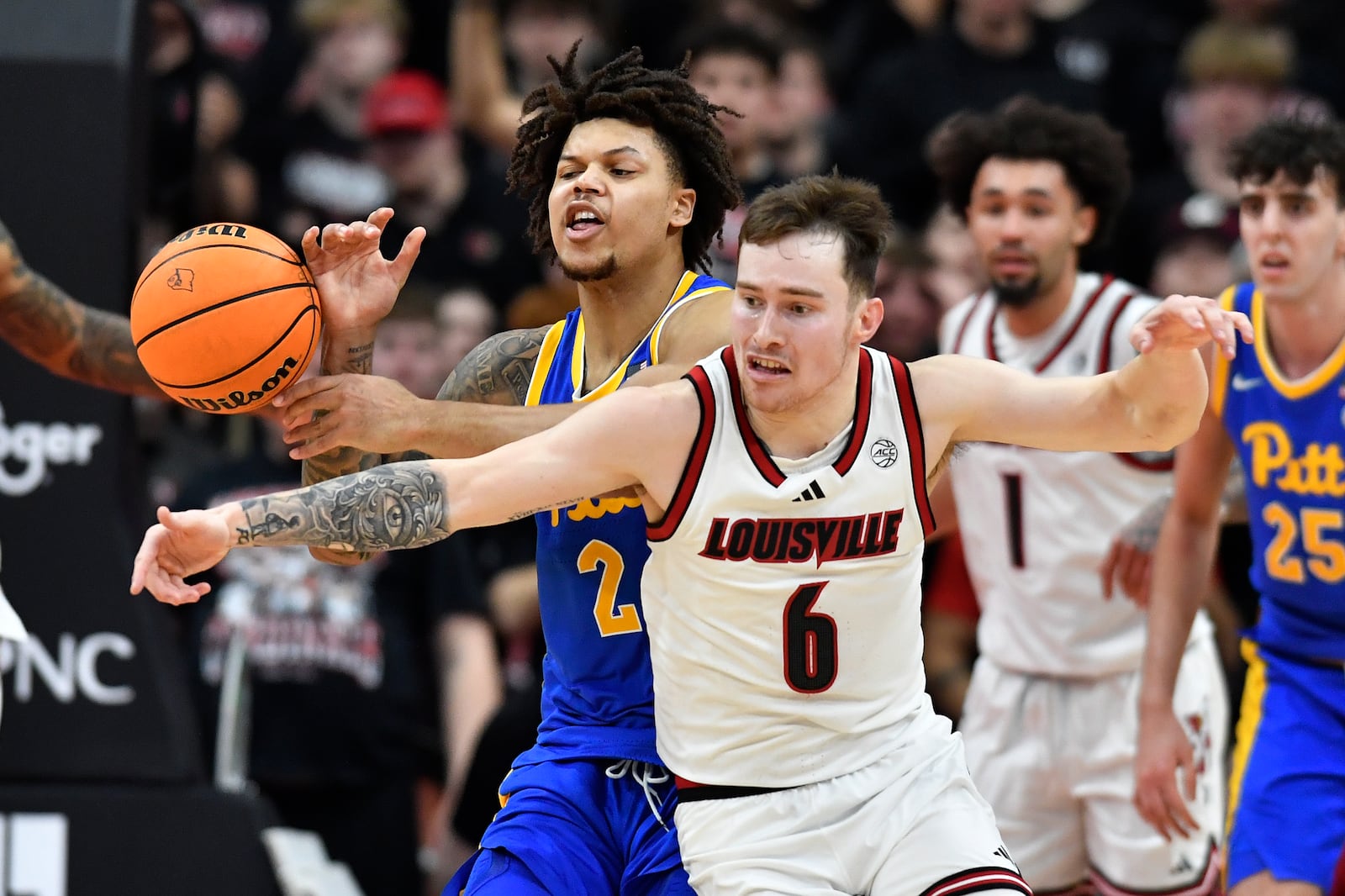 Louisville guard Reyne Smith (6) attempts to get the ball away from Pittsburgh forward Cameron Corhen (2) during the second half of an NCAA college basketball game in Louisville, Ky., Saturday, March 1, 2025. (AP Photo/Timothy D. Easley)