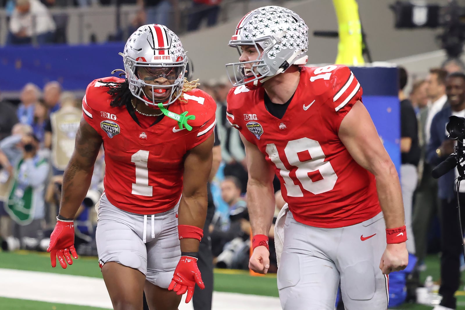 Ohio State running back Quinshon Judkins (1) celebrates after scoring a touchdown with quarterback Will Howard (18) during the second half of the Cotton Bowl College Football Playoff semifinal game against Texas, Friday, Jan. 10, 2025, in Arlington, Texas. (AP Photo/Gareth Patterson)