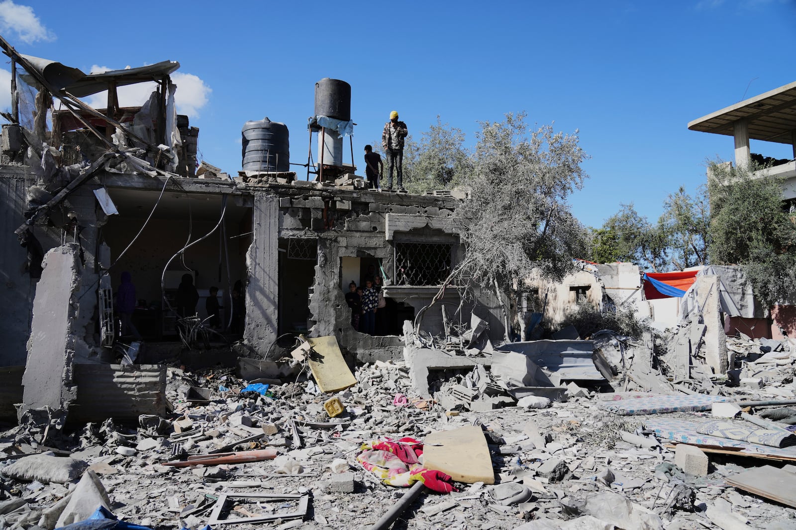 Palestinians inspect their damaged house following an Israeli bombardment in Deir al-Balah, Gaza Strip on Wednesday, March 19, 2025. (AP Photo/Abdel Kareem Hana)