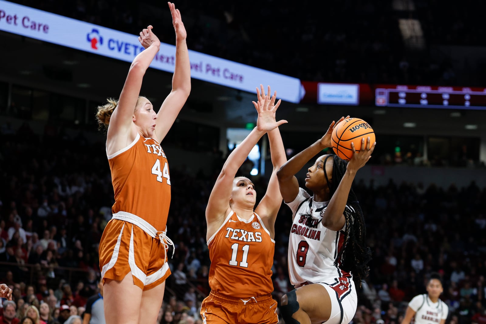 South Carolina forward Joyce Edwards (8) drives to the basket against Texas forwards Taylor Jones (44) and Justice Carlton (11) during the first half of an NCAA college basketball game in Columbia, S.C., Sunday, Jan. 12, 2025. (AP Photo/Nell Redmond)