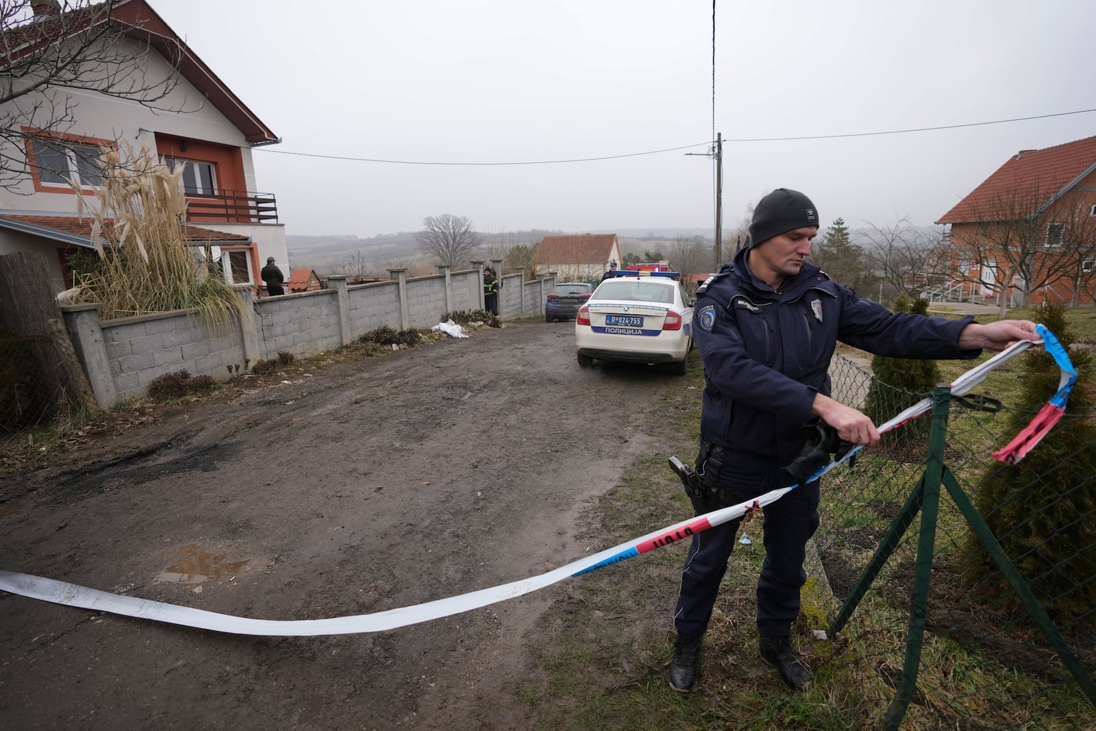 A police officer guards street in front of a home for the elderly where eight people died in a fire, in Barajevo, a municipality of Belgrade, Serbia, Monday, Jan. 20, 2025. (AP Photo/Darko Vojinovic)