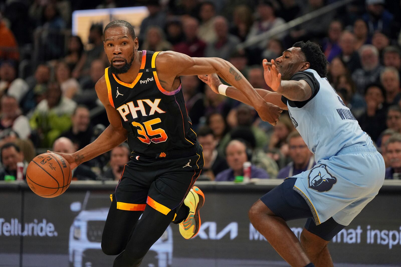 Phoenix Suns forward Kevin Durant (35) drives on Memphis Grizzlies guard Vince Williams Jr. during the first half of an NBA basketball game, Tuesday, Feb. 11, 2025, in Phoenix. (AP Photo/Rick Scuteri)