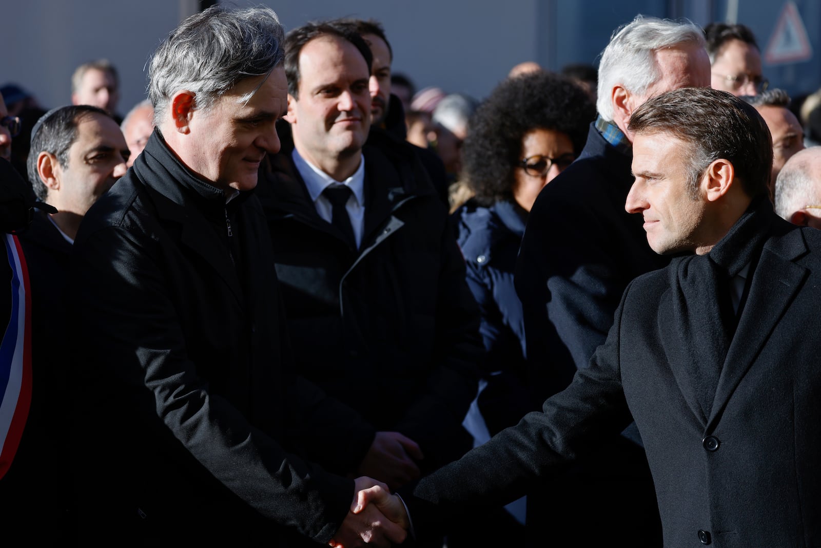 French President Emmanuel Macron, right, shakes hands with Laurent Sourisseau, known as "Riss", publishing director of French satirical magazine "Charlie Hebdo" during commemorations marking 10 years since an Islamist attack on the Charlie Hebdo satirical newspaper and the Hypercacher jewish supermarket, outside the weekly's former offices in Paris Tuesday Jan. 7, 2025. (Ludovic Marin, Pool via AP)