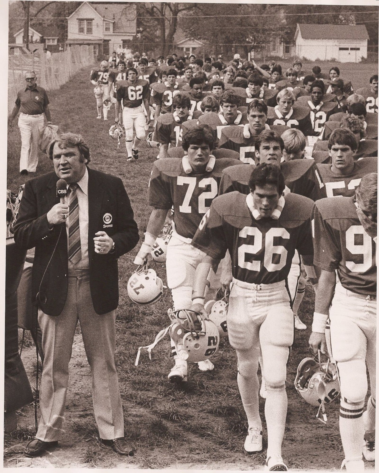 CBS broadcaster John Madden works on a segment in 1982 as Wittenberg football players file past him. Madden and Pat Summerall and Pat O’Brien broadcast the Wittenberg vs. Baldwin-Wallace game on national TV in Springfield on Oct. 3, 1982, during the NFL strike. File photo