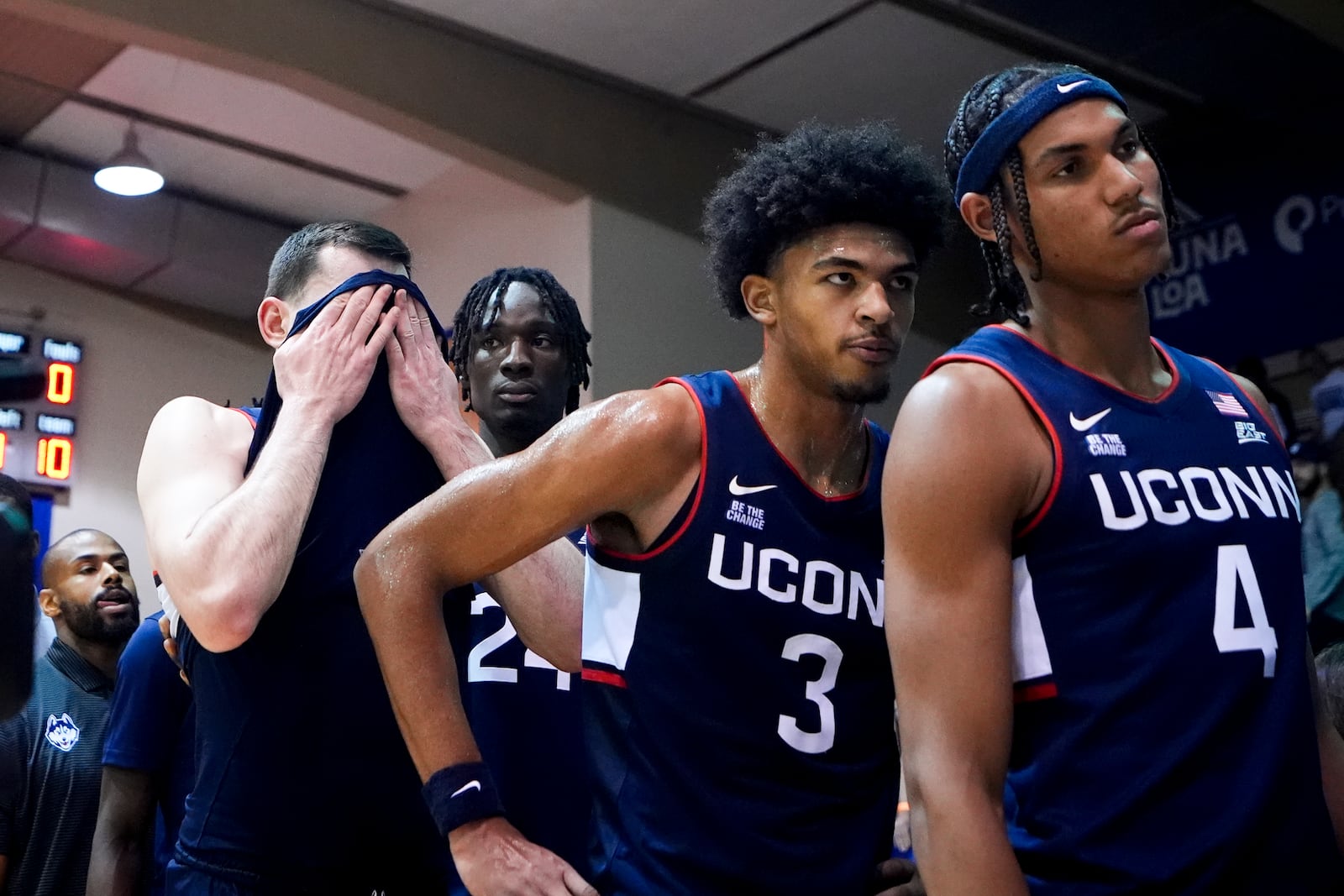 UConn forward Alex Karaban, left, wipes his face with his jersey as he and teammates, including forward Jaylin Stewart (3) and forward Isaiah Abraham (4) line up to greet Dayton after losing 85-67 in an NCAA college basketball game at the Maui Invitational Wednesday, Nov. 27, 2024, in Lahaina, Hawaii. (AP Photo/Lindsey Wasson)