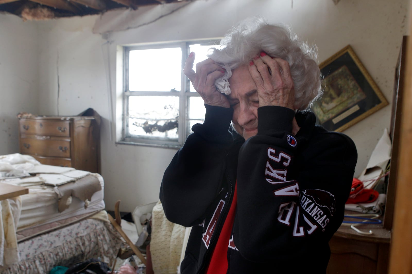 FILE- Florene Renfro, 85, breaks down as she goes through her damaged home Wednesday, May 25, 2011, in Joplin , Mo. (AP Photo/Jeff Roberson, File)