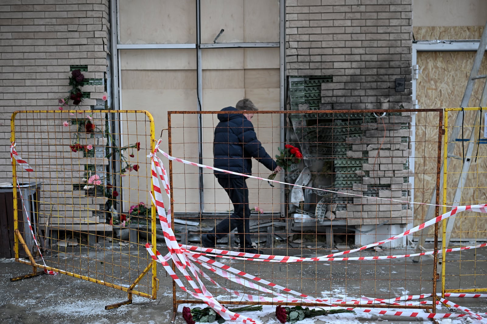 A man lays flowers at the place where Lt. General Igor Kirillov, the head of Russia's Nuclear, Biological, and Chemical Defence Forces and his assistant Ilya Polikarpov were killed by an explosive device planted close to a residential apartment's block in Moscow, Russia, Wednesday, Dec. 18, 2024. (AP Photo/Dmitry Serebryakov)