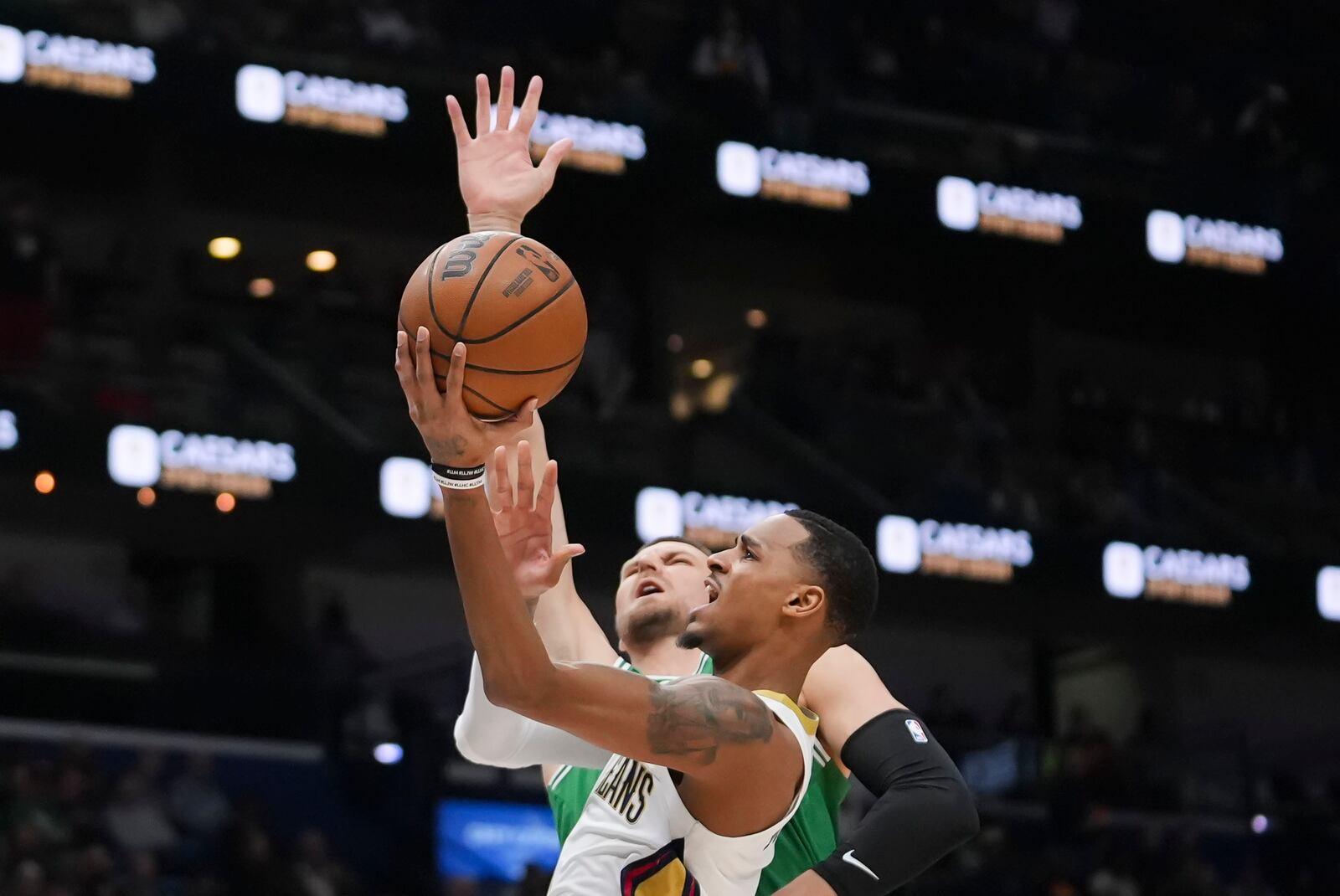 New Orleans Pelicans guard Dejounte Murray goes to the basket against Boston Celtics center Kristaps Porzingis in the first half of an NBA basketball game in New Orleans, Friday, Jan. 31, 2025. (AP Photo/Gerald Herbert)