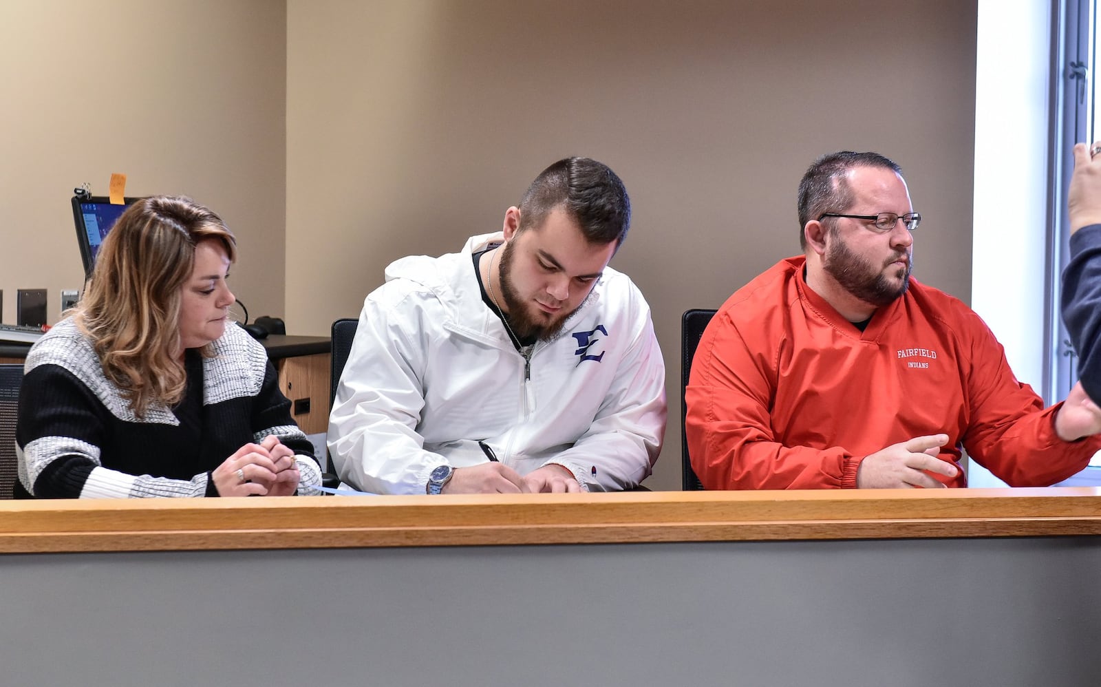 Fairfield senior Jacob Hensley (middle) sits with his parents Laura Lyon and Dave Hensley during an early National Signing Day ceremony Wednesday morning at Fairfield High School. Hensley signed with East Tennessee State University. NICK GRAHAM/STAFF