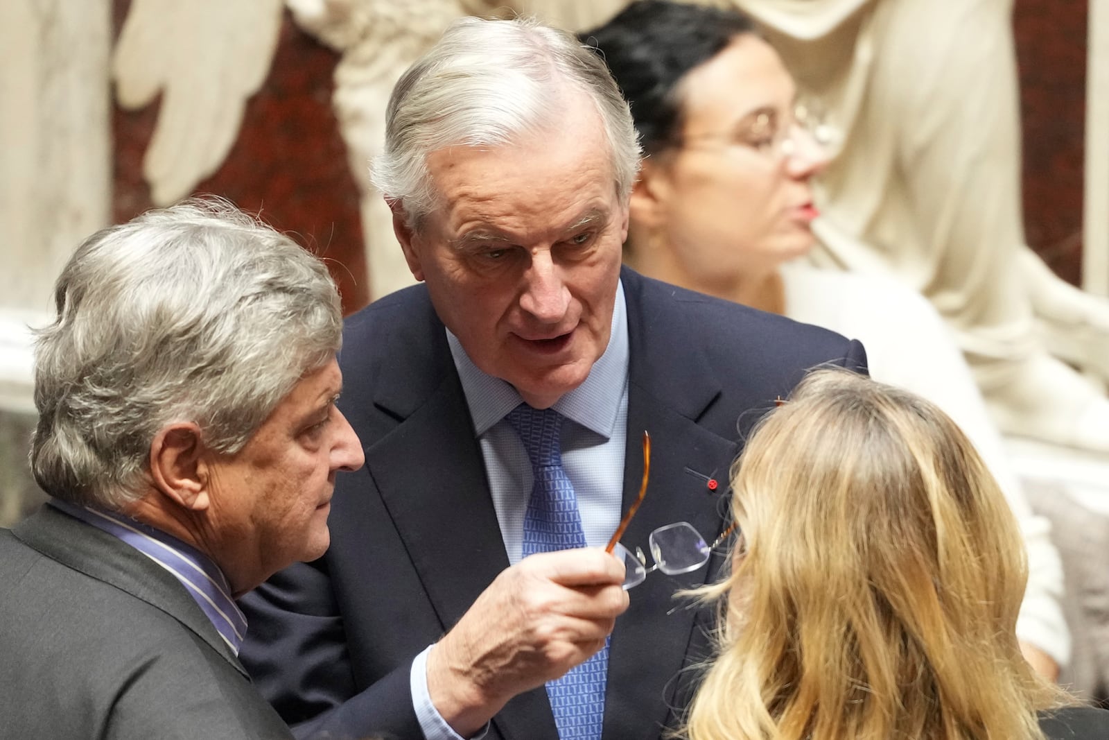 French Prime Minister Michel Barnier, center, talks to people at the National Assembly before French lawmakers vote on a no-confidence motion that could bring down the prime minister and the government for the first time since 1962, Wednesday, Dec. 4, 2024 in Paris. (AP Photo/Michel Euler)