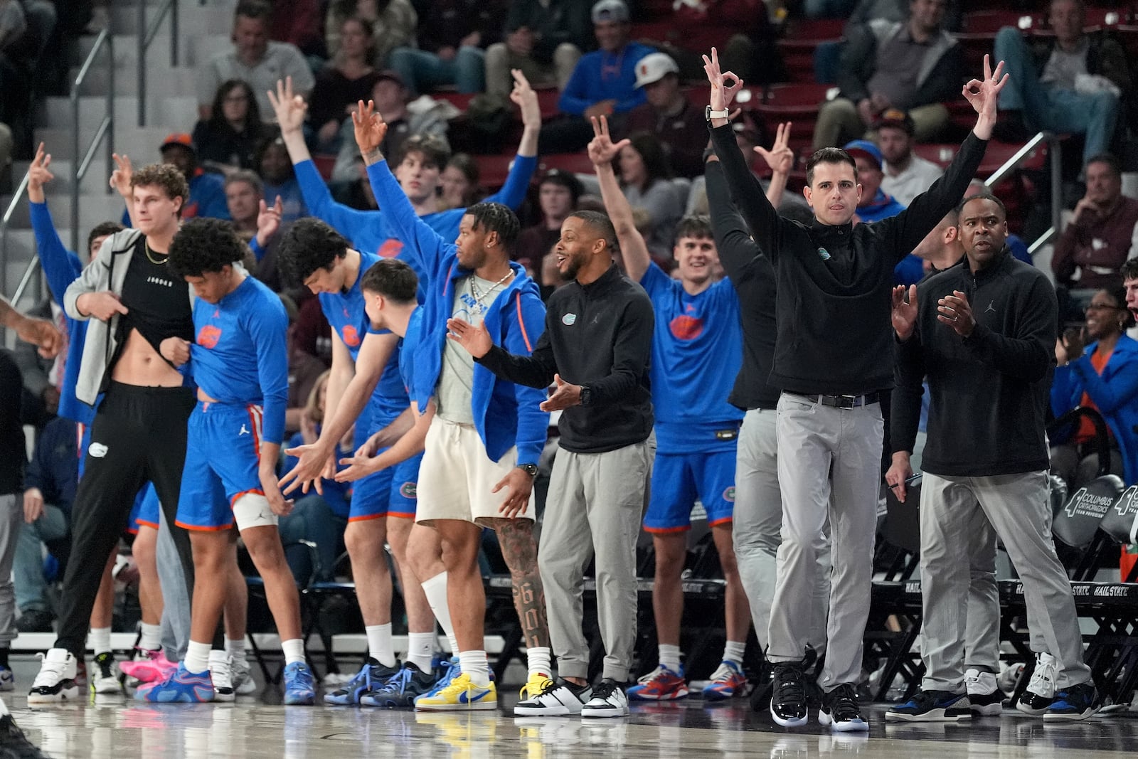 The Florida team bench joins their head coach Todd Golden, right, in celebrating one of their players scoring a three-point shot during the second half of an NCAA college basketball game against Mississippi State, Wednesday, Feb. 11, 2025, in Starkville, Miss. (AP Photo/Rogelio V. Solis)