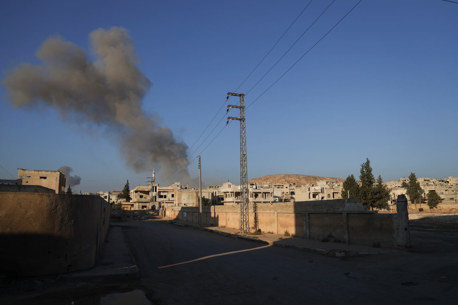 Smoke from an airstrike by government forces billows in the sky over the town of Khan Sheikhoun, south of Idlib, Syria, Tuesday, Dec. 3, 2024. (AP Photo/Omar Albam)