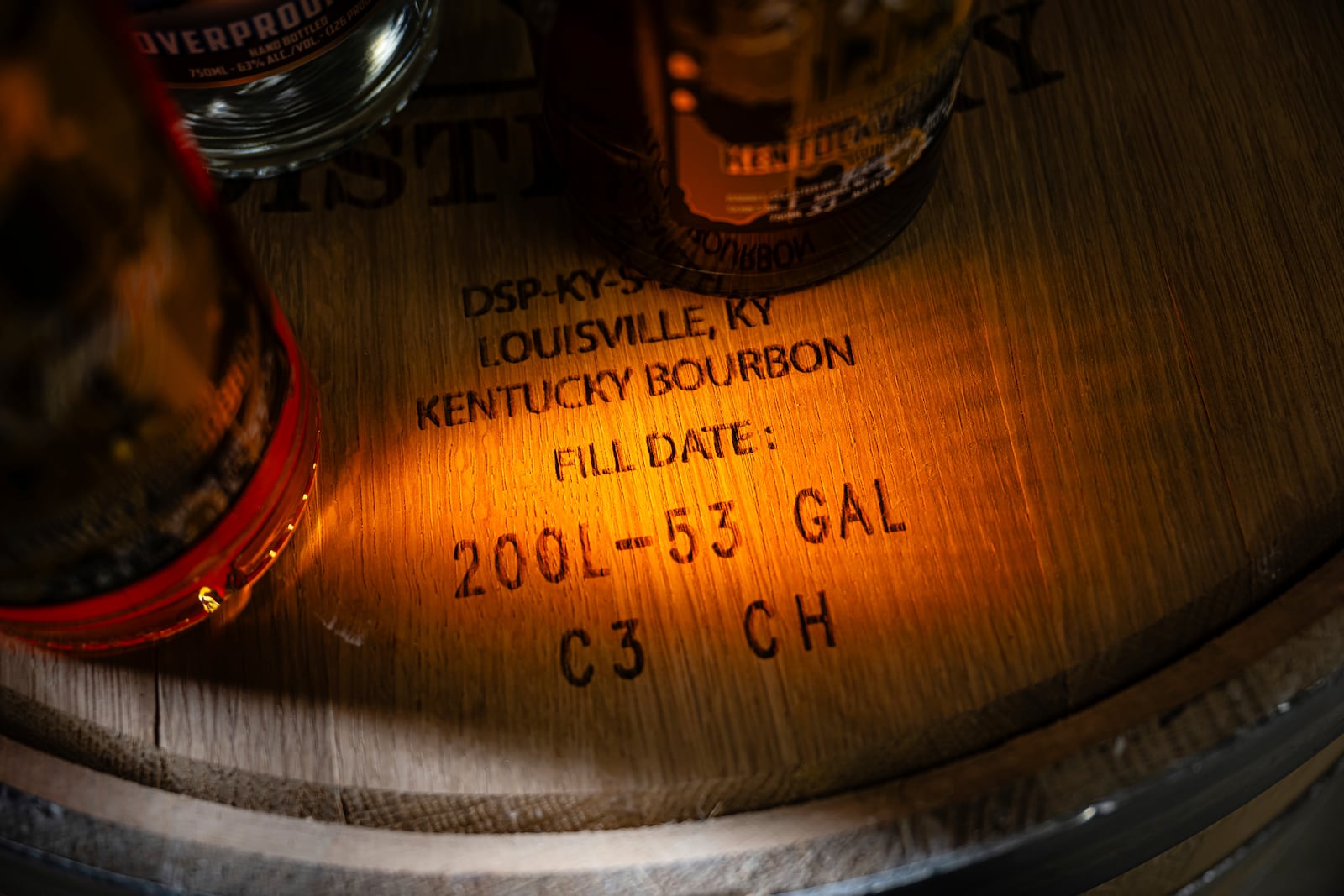 Labeling on the head of a bourbon barrel is seen near bottles of product at the Brough Brothers Distillery which is under construction in Louisville, Ky., Saturday, March 8, 2025. (AP Photo/Jon Cherry)