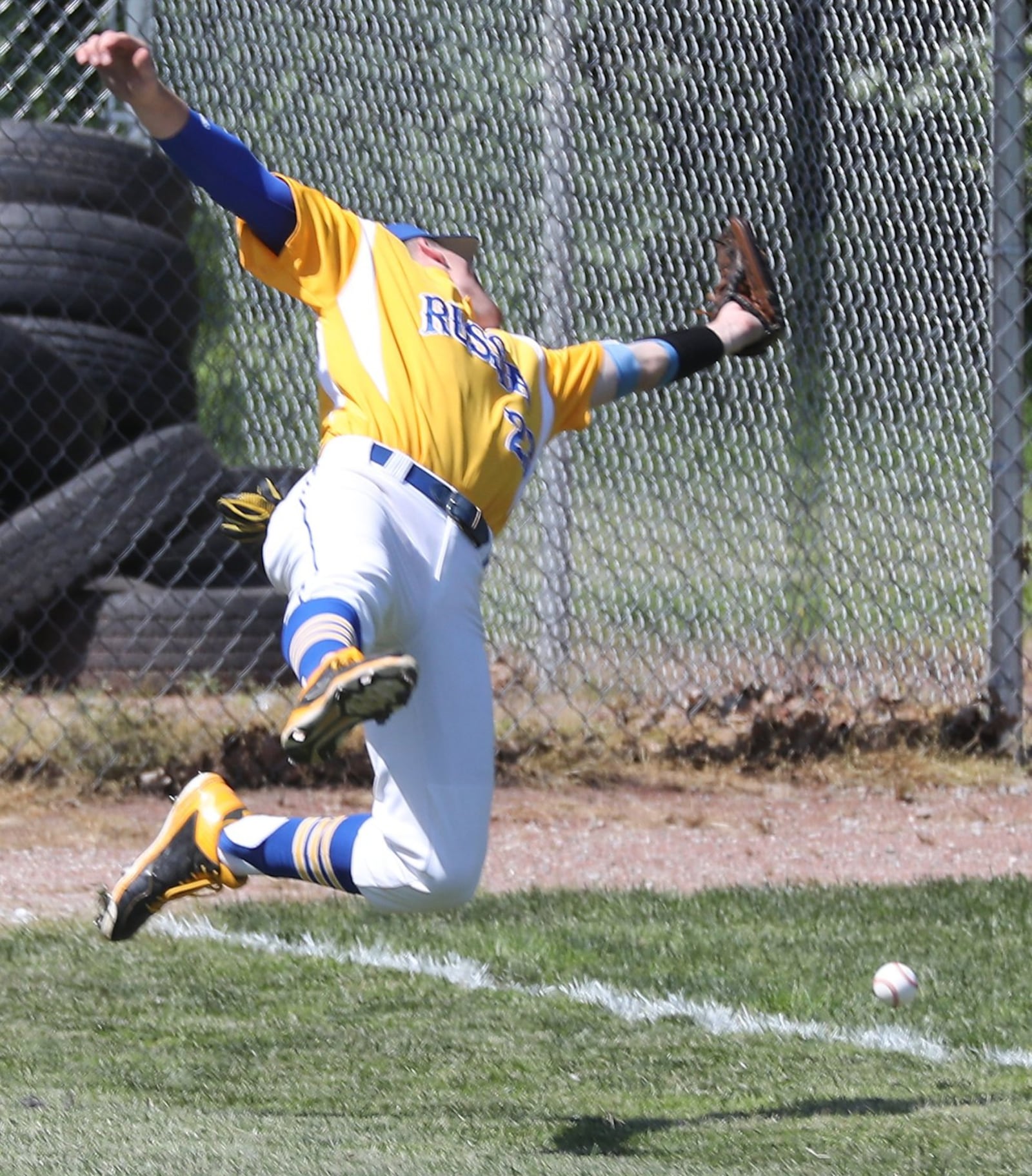 Russia left fielder Jordan York tumbles backward as he tries to field a Cincinnati Christian foul ball during Thursday’s Division IV regional semifinal at Carleton Davidson Stadium in Springfield. BILL LACKEY/STAFF