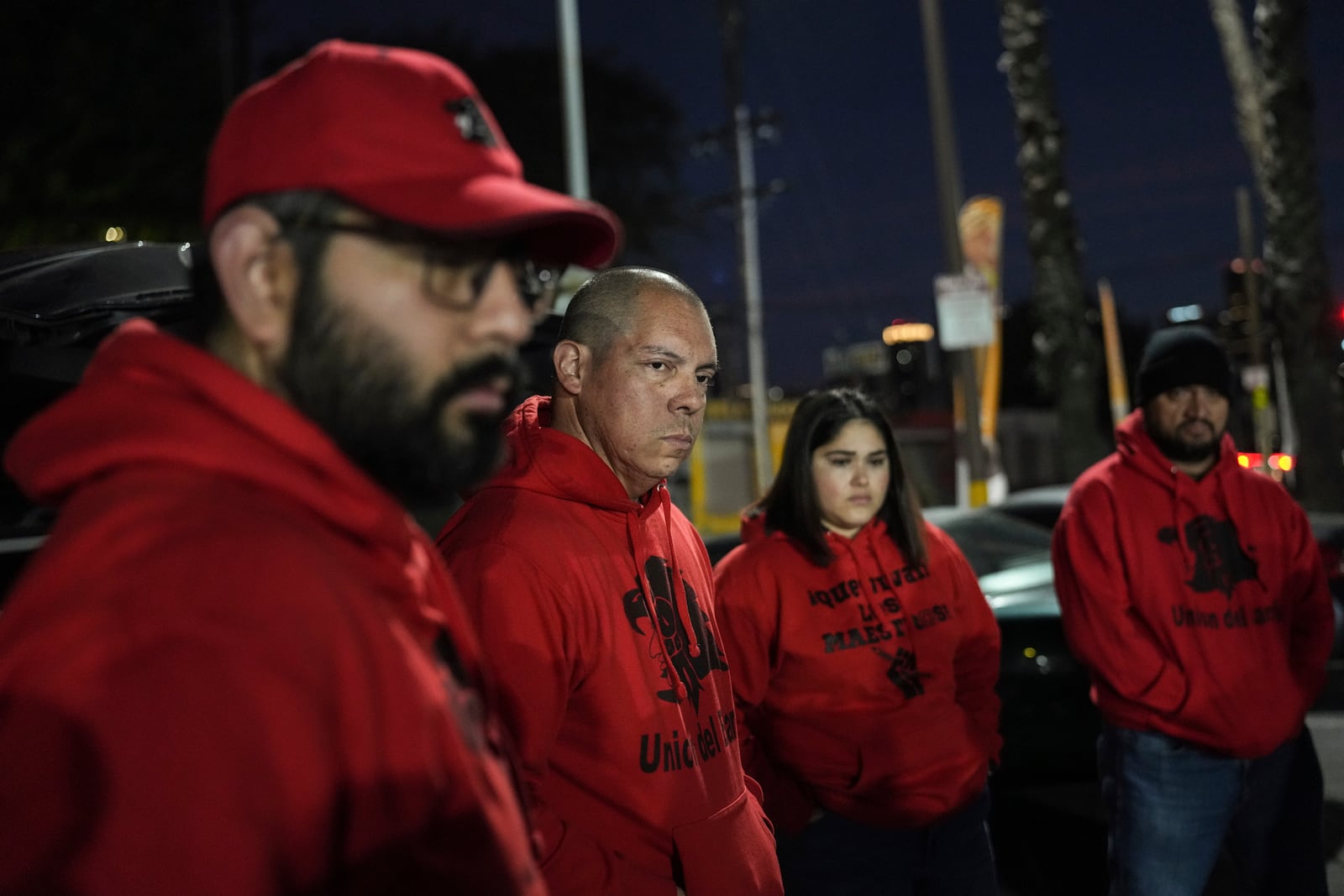 Ron Gochez, second from left, a teacher volunteering with Union del Barrio, an organization advocating for immigrant rights, listens to other volunteers as they gather in a parking lot before searching for ICE activity in Los Angeles Thursday, Feb. 27, 2025. (AP Photo/Jae C. Hong)