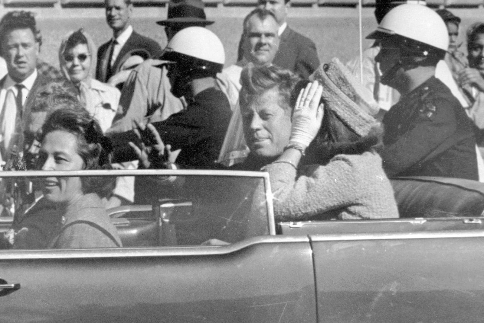 FILE - President John F. Kennedy waves from his car in a motorcade in Dallas, with first lady Jacqueline Kennedy, right, Nellie Connally, second from left, and her husband, Texas Gov. John Connally, far left, Nov. 22, 1963. (AP Photo/Jim Altgens, File)