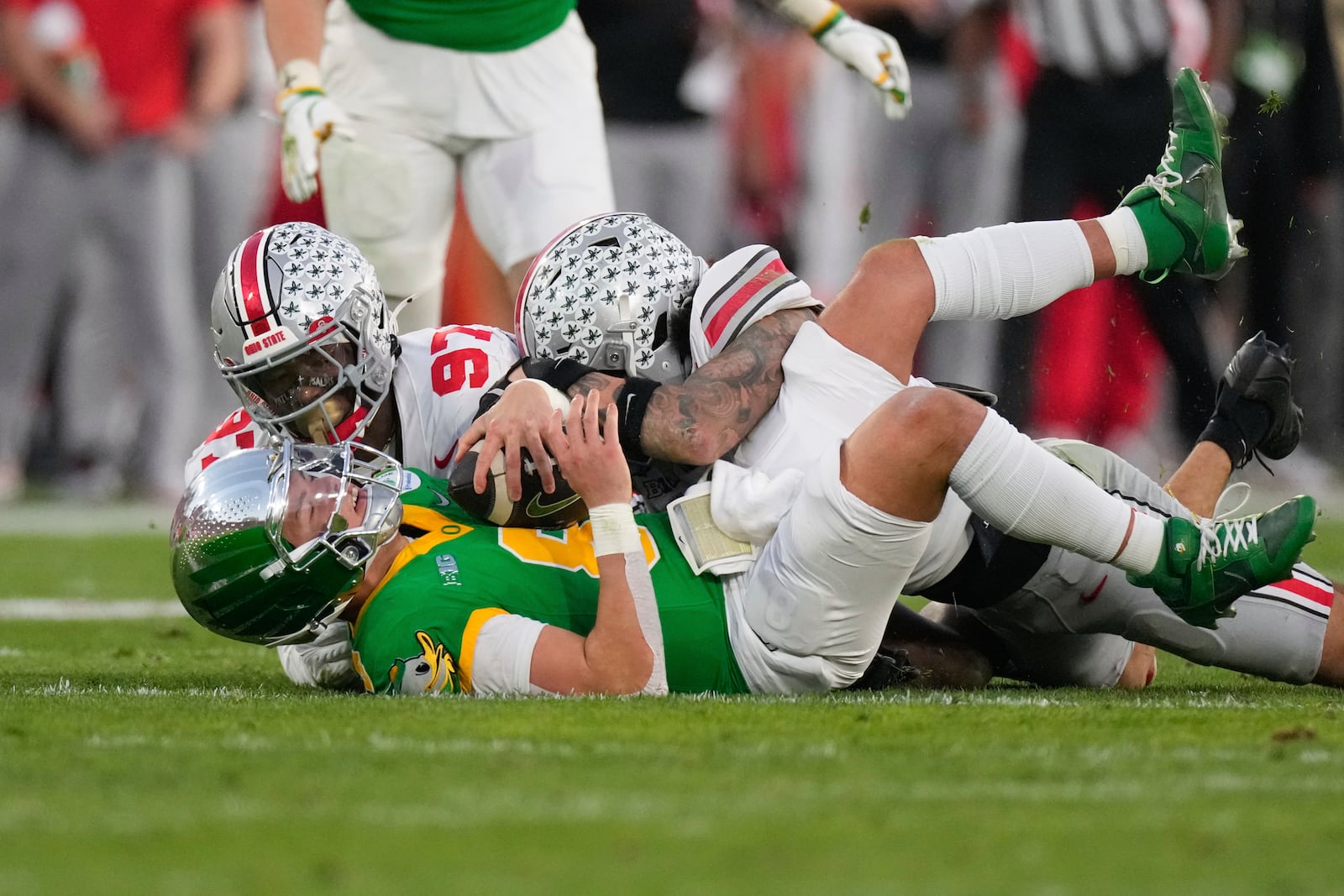 Ohio State defensive end Kenyatta Jackson Jr. (97) and safety Lathan Ransom (8) sack Oregon quarterback Dillon Gabriel (8) during the second half in the quarterfinals of the Rose Bowl College Football Playoff, Wednesday, Jan. 1, 2025, in Pasadena, Calif. (AP Photo/Mark J. Terrill)