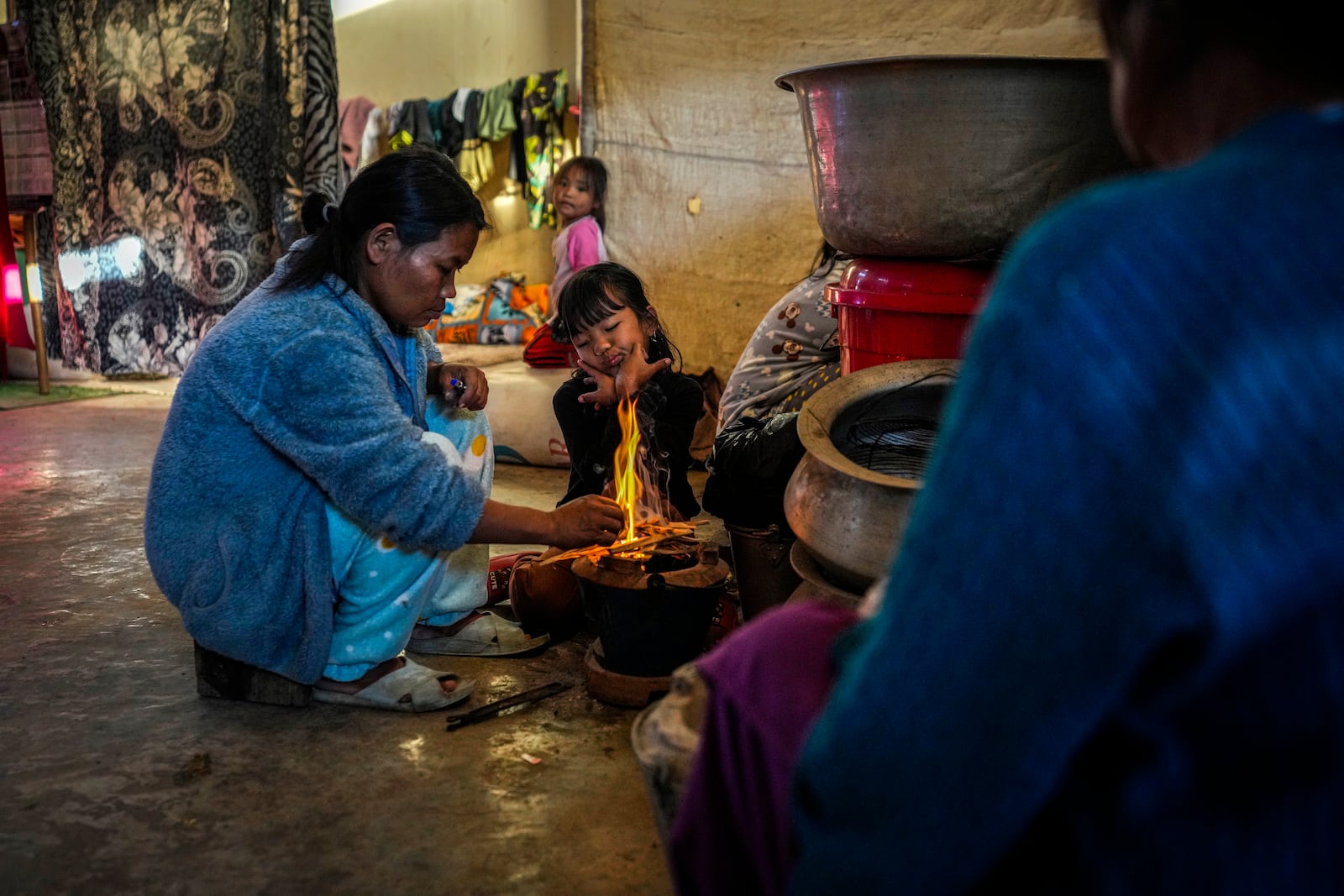 A Kuki tribal woman lights fire to prepare food in a relief camp in Kangpokpi, Manipur, Sunday, Dec. 15, 2024. (AP Photo/Anupam Nath)