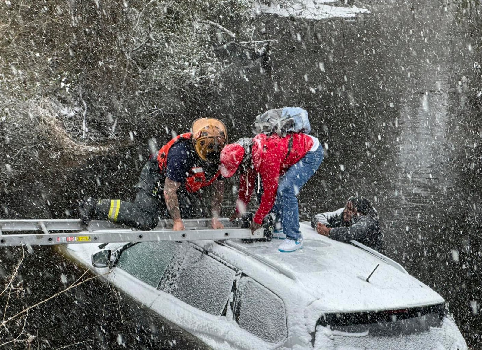 This image provided by the City of Suffolk Department of Fire & Rescue shows emergency workers rescuing a person from an SUV that crashed into water Wednesday, Feb. 19, 2025 in Suffolk, Va. (City of Suffolk Department of Fire & Rescue via AP)