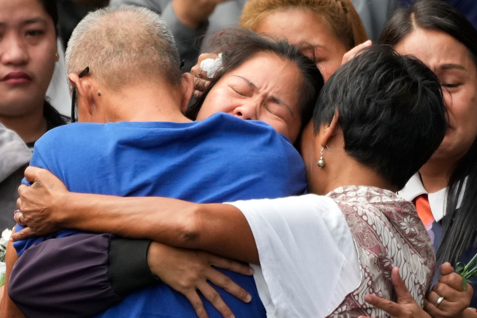 Mary Jane Veloso, center, a Filipino woman who spent almost 15 years in an Indonesian prison for drug trafficking and was nearly executed by firing squad in 2015, is reunited with her family as she arrives at the Correctional Institution for Women in Mandaluyong, Philippines Wednesday, Dec. 18, 2024. (AP Photo/Aaron Favila)