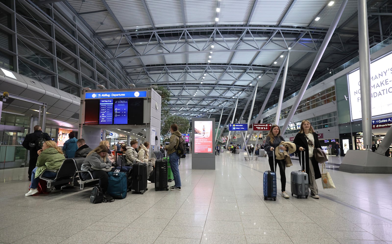 Only a few travelers are on the move in the departure area of the terminal building at Dusseldorf Airport, Germany Monday, March 10, 2025. (Christoph Reichwein/dpa via AP)