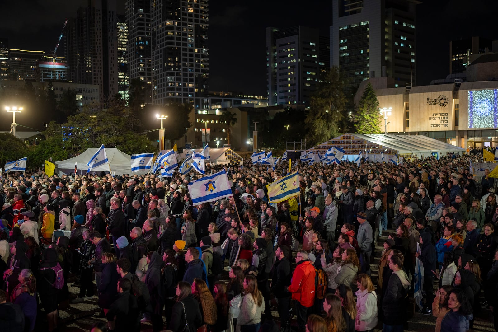 People gather at the so-called 'Hostages Square' in Tel Aviv, Israel, Thursday, Feb. 20, 2025, hours after the bodies of four Israeli hostages, Shiri Bibas, her two children, Ariel and Kfir, and Oded Lifshitz were handed over by Palestinian militant groups in Gaza to Israel. (AP Photo/Oded Balilty)