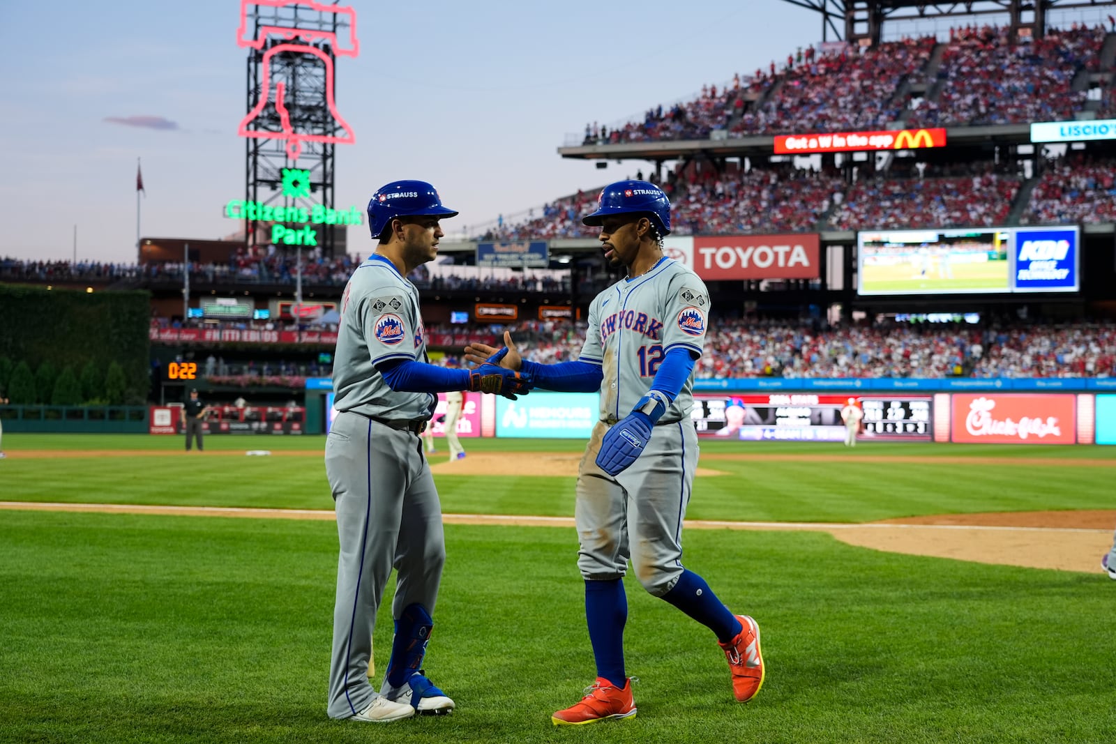 New York Mets' Francisco Lindor (12) celebrates with Jose Iglesias after scoring on a hit by Brandon Nimmo during the eighth inning of Game 1 of a baseball NL Division Series against the Philadelphia Phillies, Saturday, Oct. 5, 2024, in Philadelphia. (AP Photo/Chris Szagola)