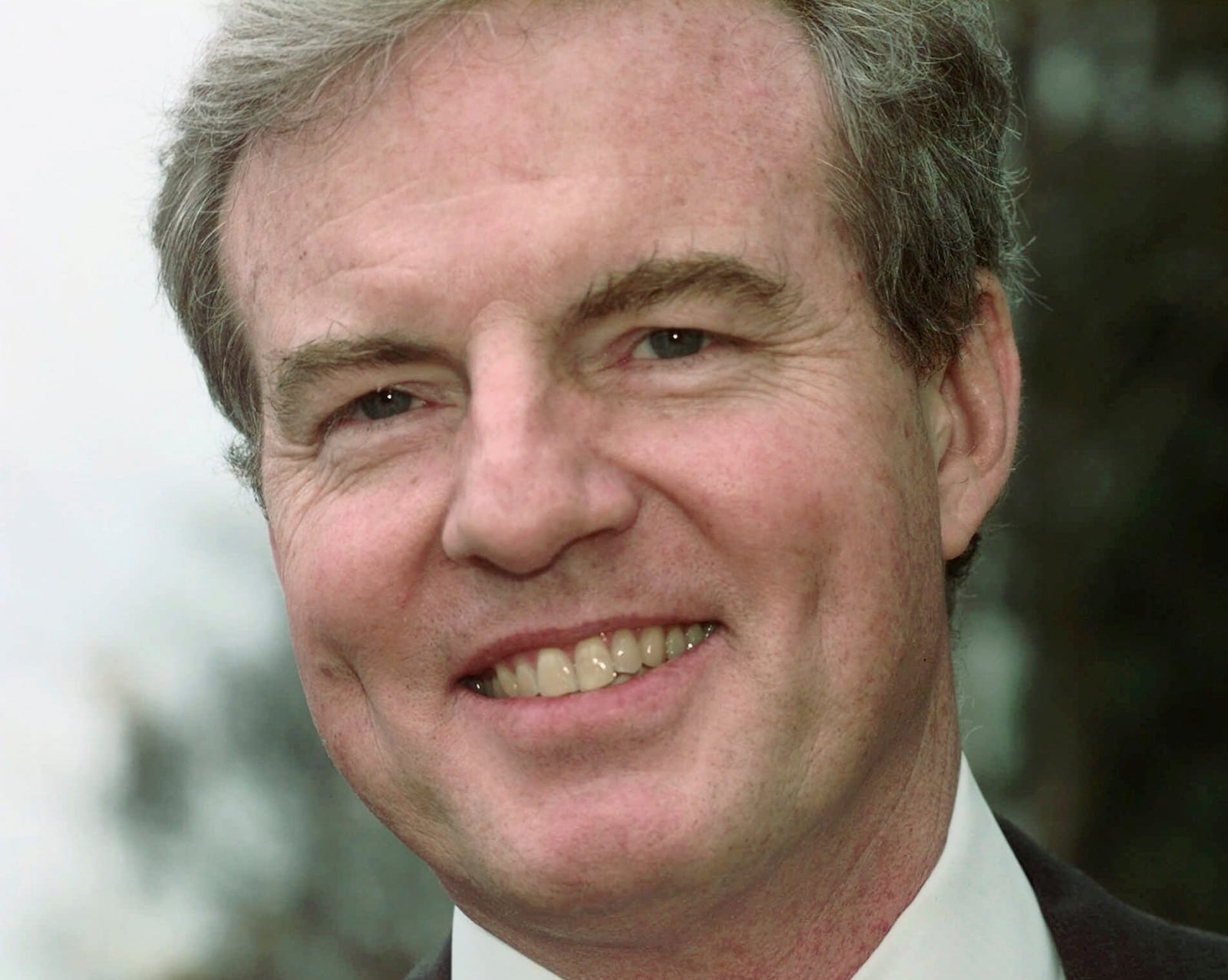 FILE - Former Arkansas Gov. Jim Guy Tucker smiles as he leaves the Little Rock federal courthouse after paring prospective jurors for his next criminal trial on his first day out of home detention from his 1996 Whitewater conviction, Feb. 19, 1998. (AP Photo/Danny Johnston, File