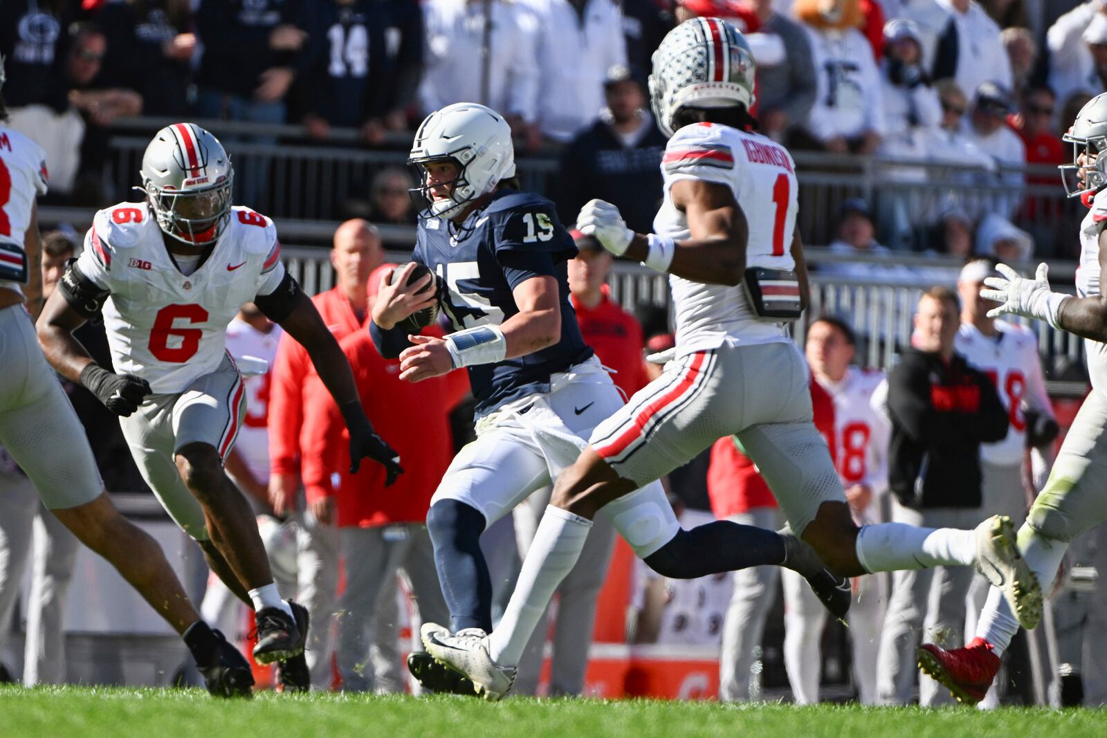 Penn State quarterback Drew Allar (15) runs between Ohio State defenders Sonny Styles (6) and Davison Igbinosun (1) during the second quarter of an NCAA college football game, Saturday, Nov. 2, 2024, in State College, Pa. (AP Photo/Barry Reeger)