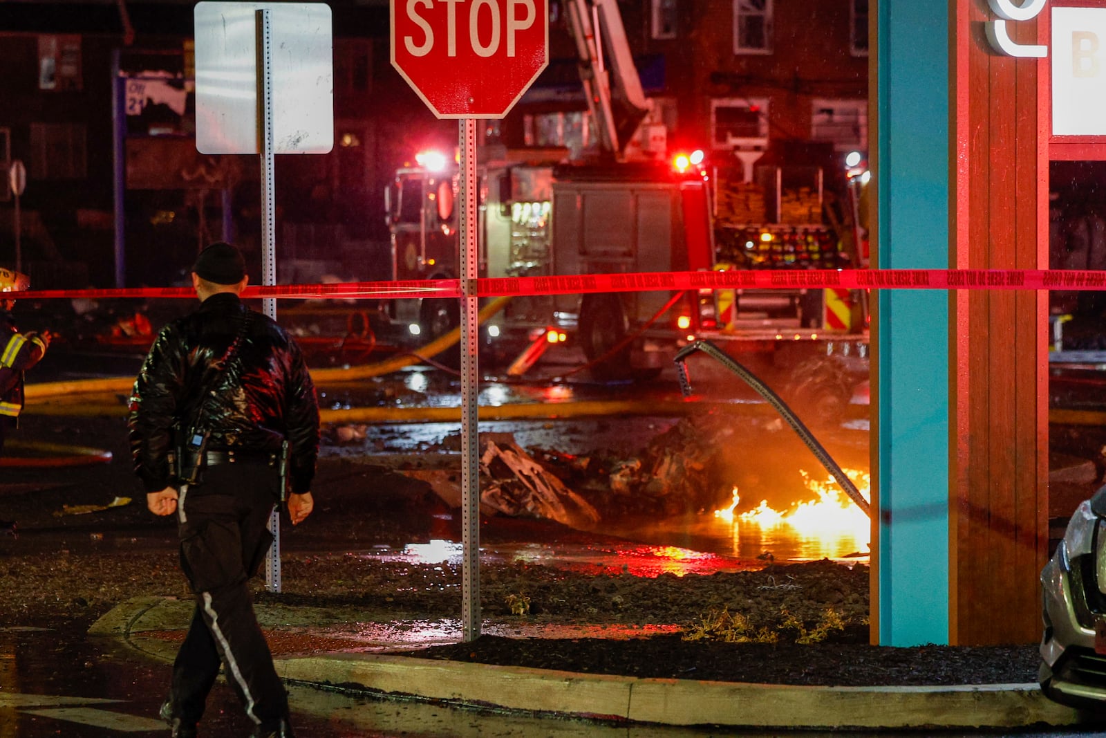 FILE - Fuel burns in the street at Bustleton and Cotton Ave. after a small plane crashed near Roosevelt Mall, Friday, Jan. 31, 2025, in Philadelphia. (Steven M. Falk/The Philadelphia Inquirer via AP, File)