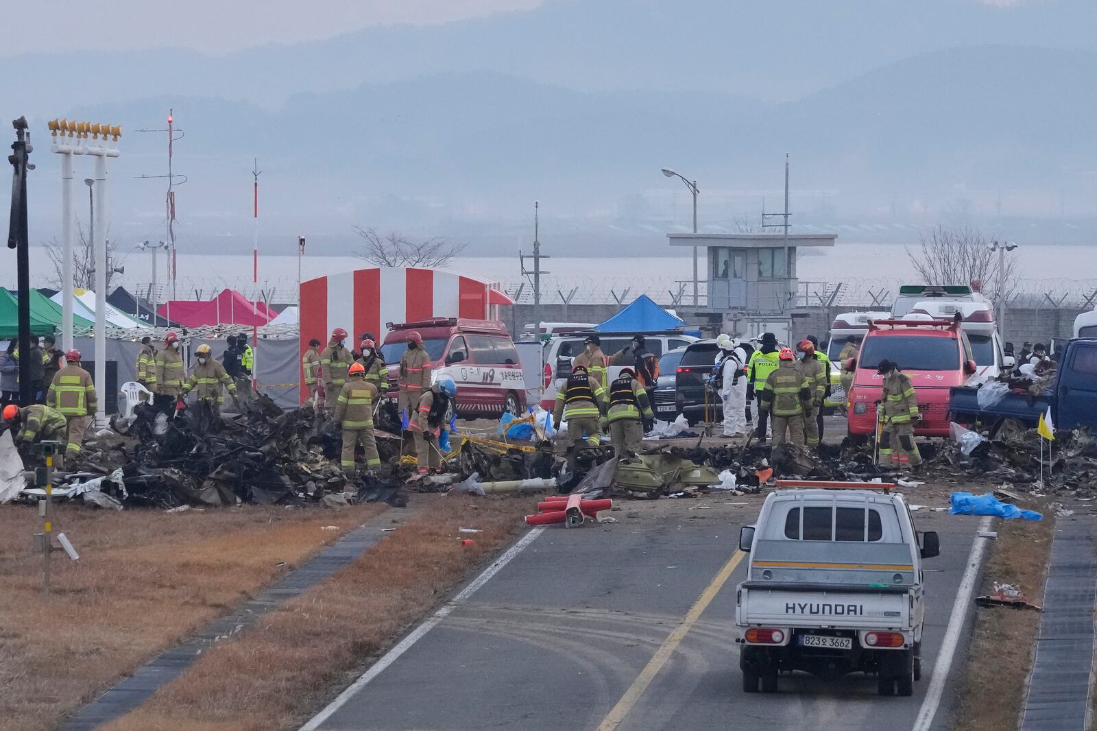 Rescue team members work at the site of a plane fire at Muan International Airport in Muan, South Korea, Monday, Dec. 30, 2024. (AP Photo/Ahn Young-joon)