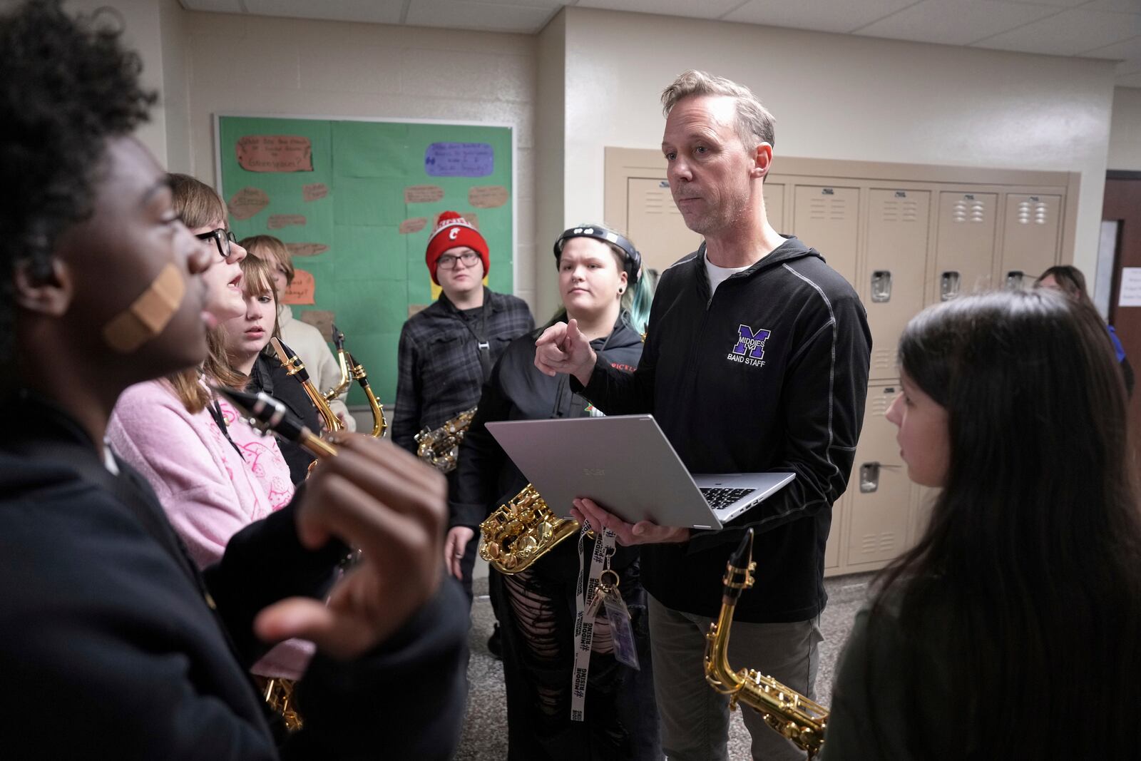 Middletown High School band director David Leisten, center, organizes students during practice within the hallways of the school on account of the cold weather, Tuesday, Jan. 14, 2025, in Middletown, Ohio. The band is set to participate in the inauguration of President-elect Donald Trump on Jan. 20. Middletown is the hometown of Vice President-elect JD Vance.(AP Photo/Kareem Elgazzar)