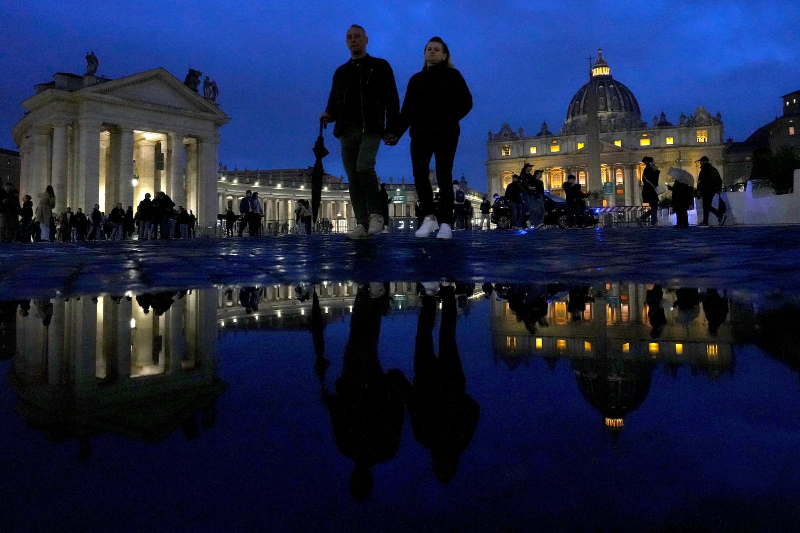 People walk outside St. Peter's Square at The Vatican, Monday, Feb. 24, 2025. (AP Photo/Kirsty Wigglesworth)