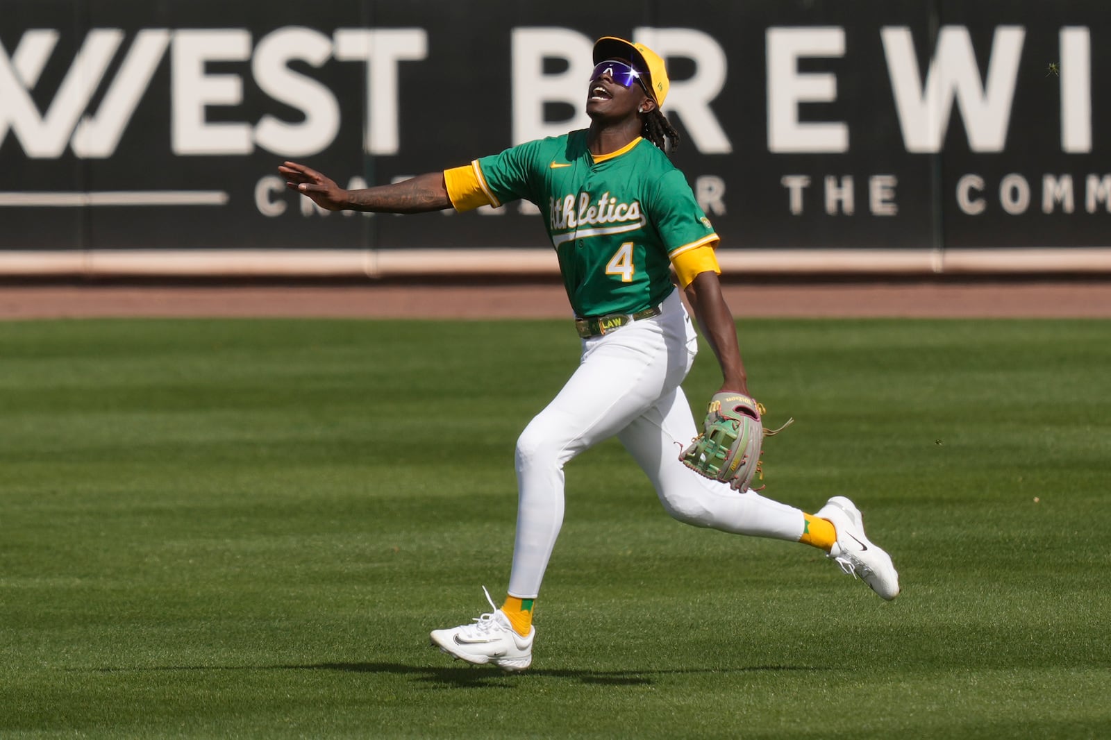 Athletics right fielder Lawrence Butler shouts runs to catch a fly ball hit by Cincinnati Reds' Jeimer Candelario during the second inning of a spring training baseball game, Friday, Feb. 28, 2025, in Mesa, Ariz. (AP Photo/Carolyn Kaster)