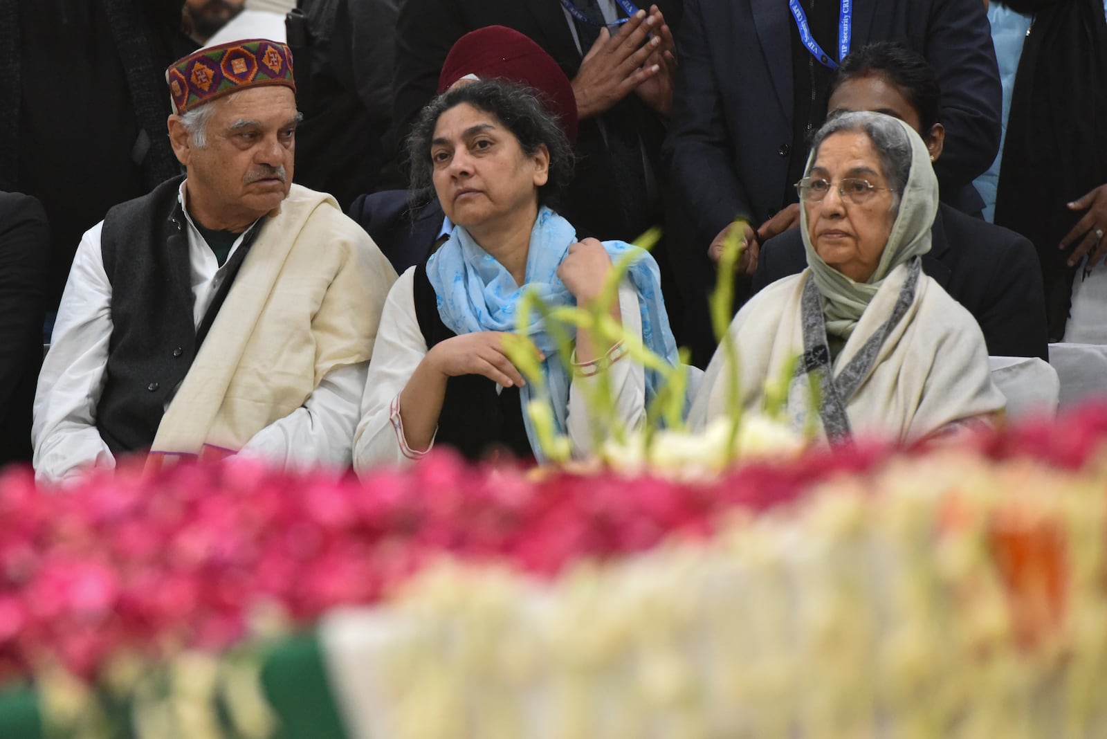 Gursharan Kaur, right, wife of former Indian Prime Minister Manmohan Singh, sits with others next to the casket of her late husband at Congress party headquarters in New Delhi, India, Saturday, Dec. 28, 2024. (AP Photo)