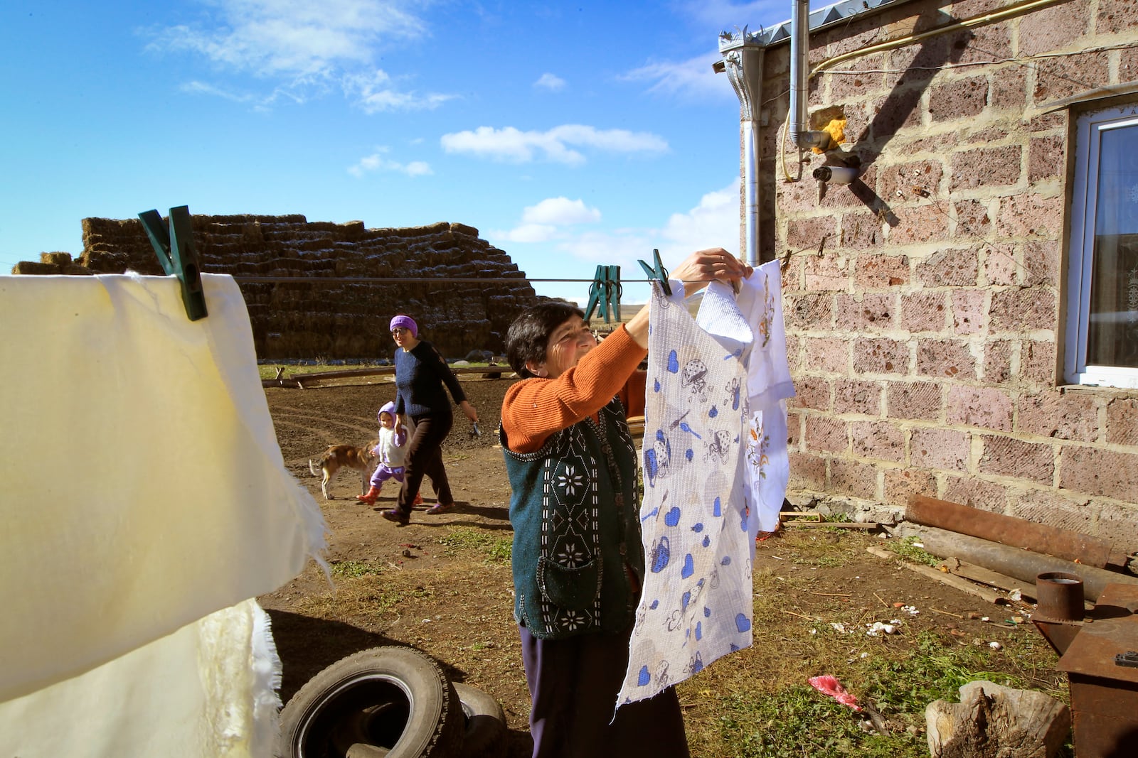 Rimma Agayan hangs up washing on a sunny autumn day outside her home in the Javakheti region, Georgia, Tuesday, Oct. 22, 2024. (AP Photo/Shakh Aivazov)