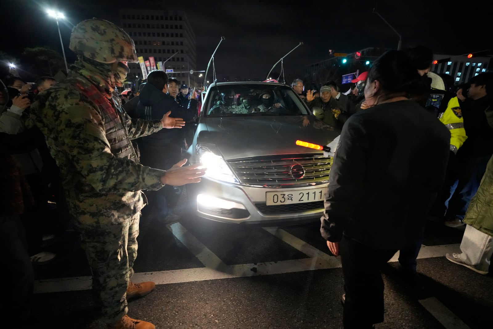 People bock a martial law vehicle as they gather to demand South Korean President Yoon Suk Yeol to step down in front of the National Assembly in Seoul, South Korea, Wednesday, Dec. 4, 2024. (AP Photo/Ahn Young-joon)