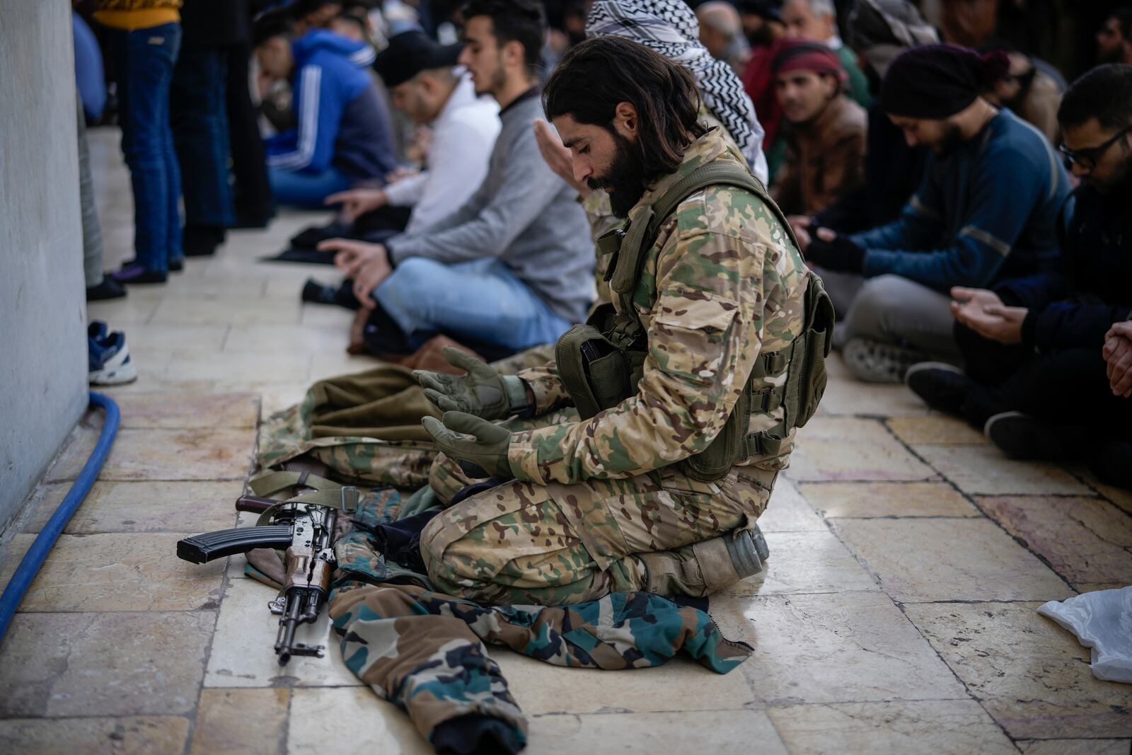 A Syrian fighter attends Friday prayers at the Umayyad Mosque, in Damascus, Syria, Friday, Dec. 20, 2024. (AP Photo/Leo Correa)