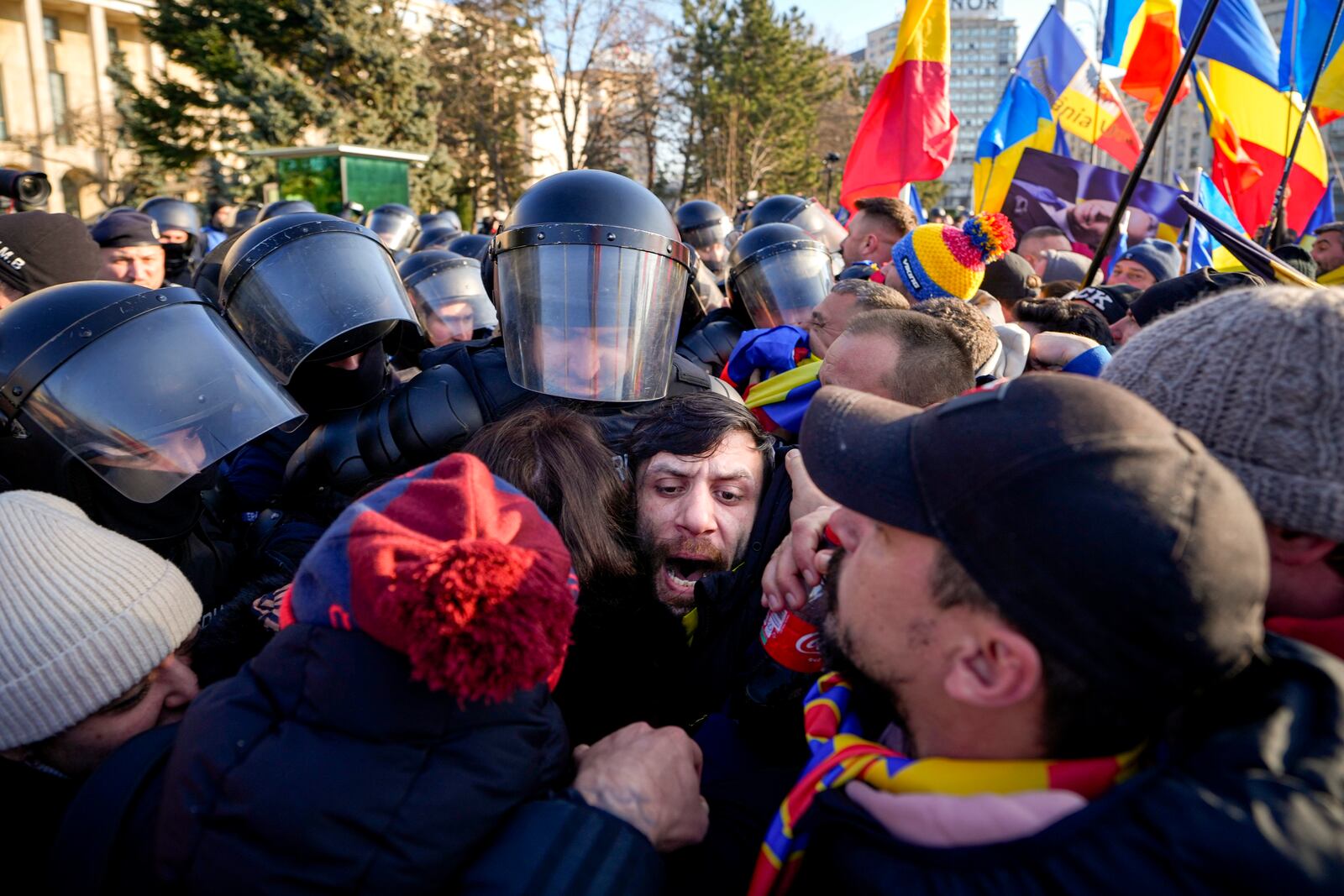 Riot police scuffle with supporters of Calin Georgescu, the winner of Romania's first round of presidential election which the Constitutional Court later annulled, who broke through police lines in front of the government headquarters, in Bucharest, Romania, Monday, Feb. 10, 2025. (AP Photo/Vadim Ghirda)