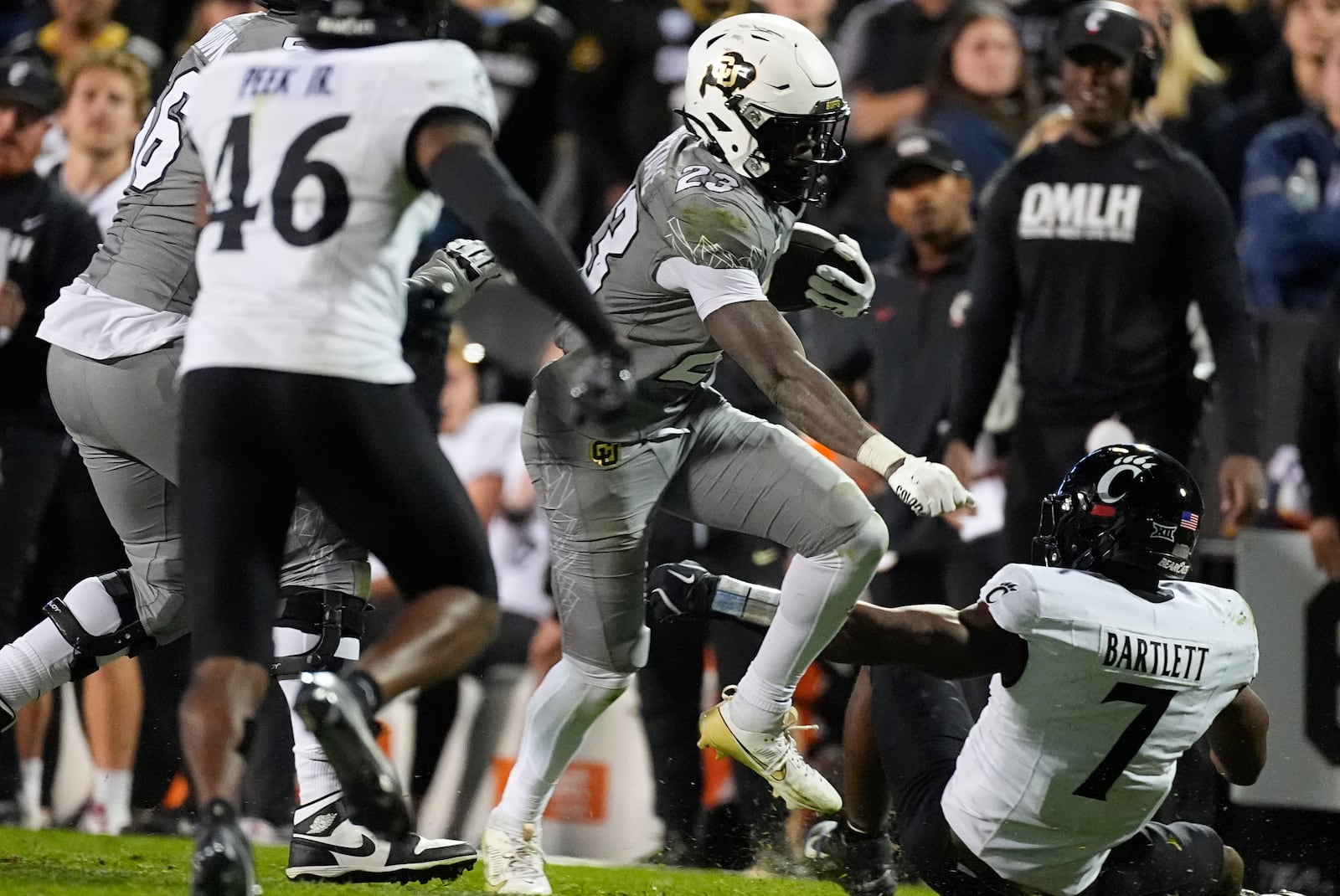 Colorado running back Isaiah Augustave, center, runs for a short gain between Cincinnati linebackers Antwan Peek Jr., left and Jared Bartlett in the second half of an NCAA college football game Saturday, Oct. 26, 2024, in Boulder, Colo. (AP Photo/David Zalubowski)