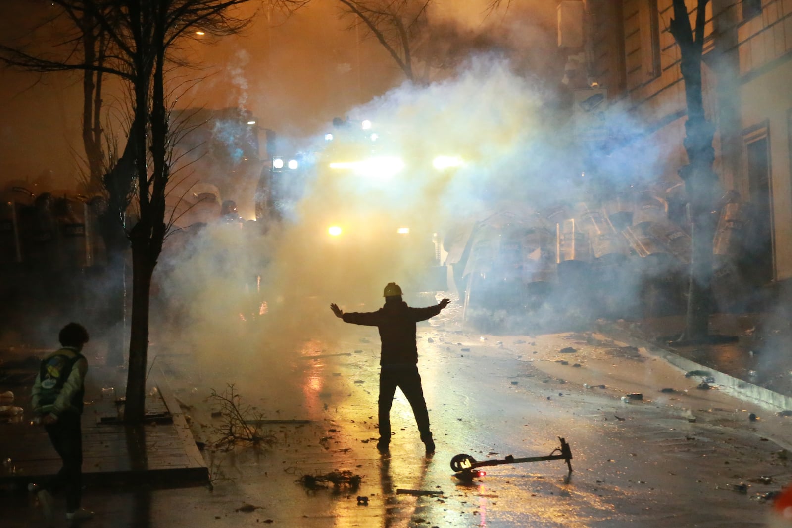 A demonstrator gestures as police block a street as protesters rally against the government's decision to suspend negotiations on joining the European Union for four years, outside the parliament's building in Tbilisi, Georgia, early Sunday, Dec. 1, 2024. (AP Photo/Zurab Tsertsvadze)