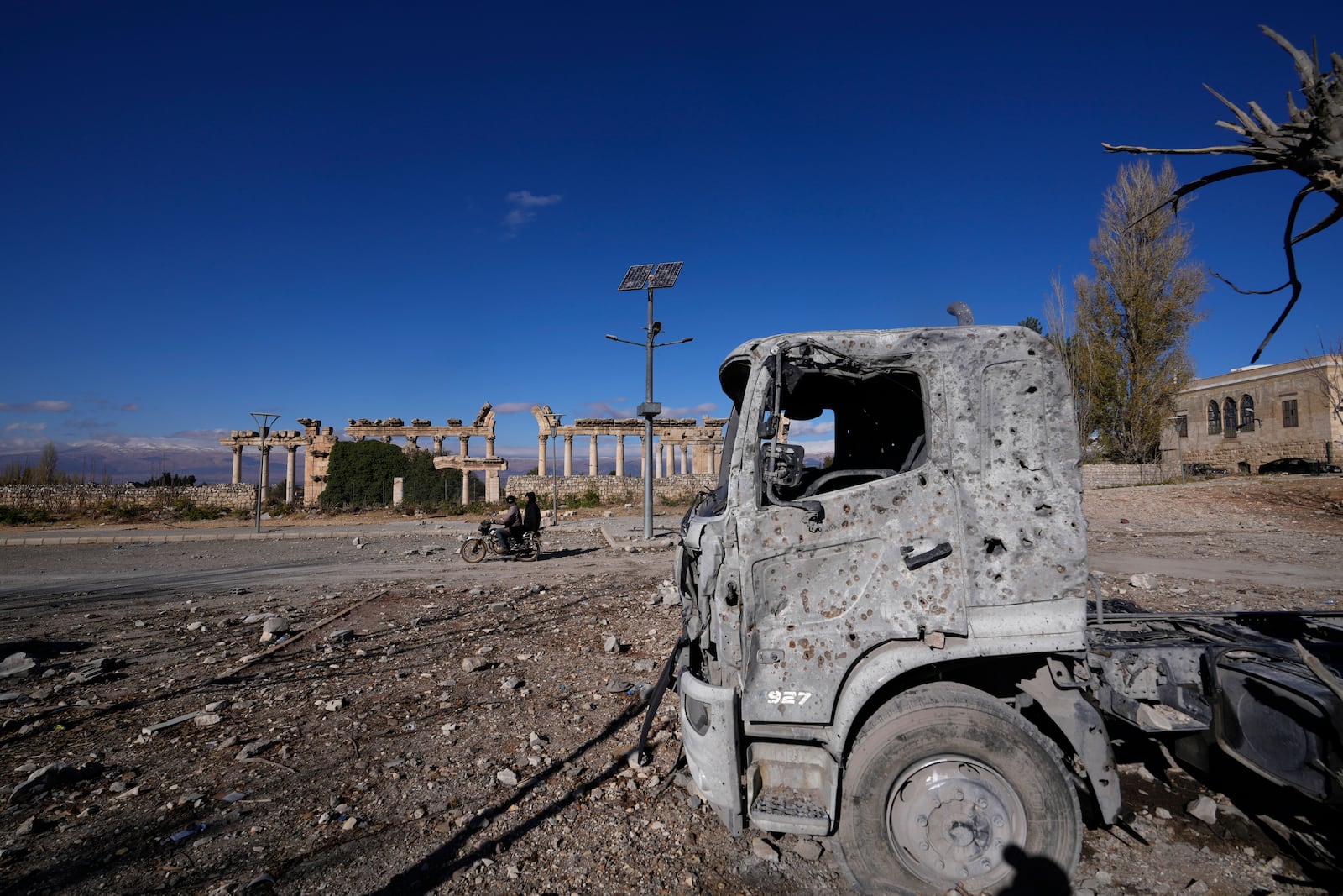 A damaged vehicle seen in front of part of the Roman temples of Baalbek in eastern Lebanon, Thursday, Nov. 28, 2024. (AP Photo/Hassan Ammar)