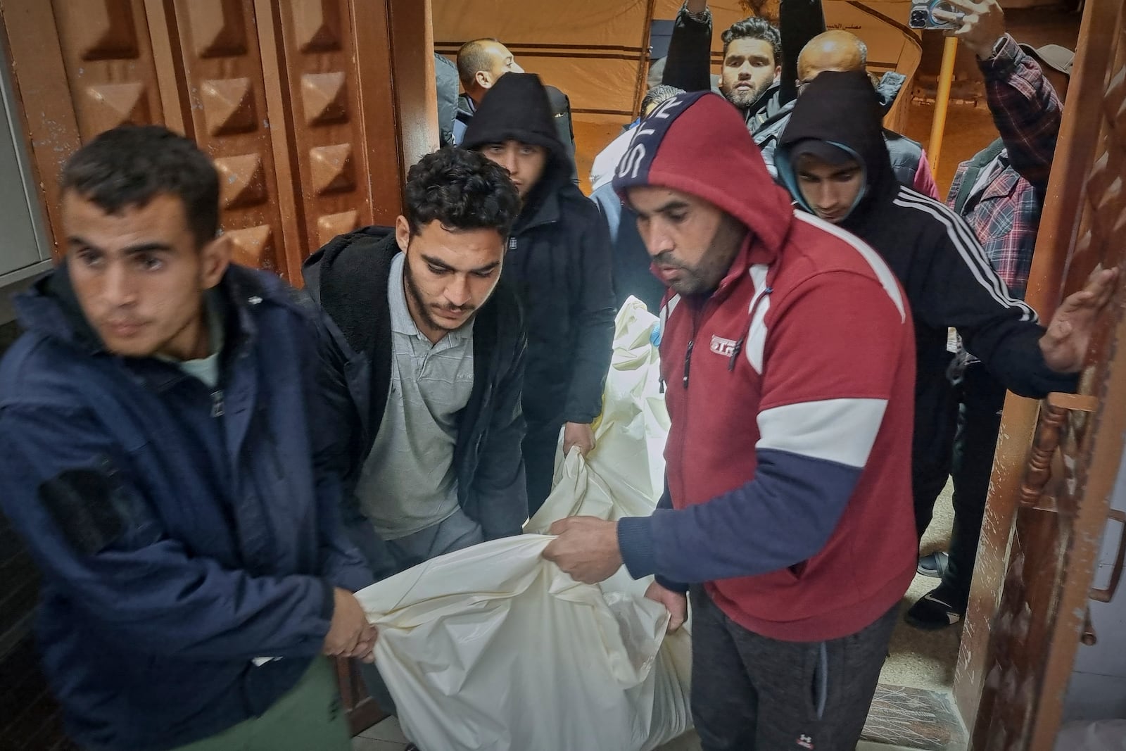 A dead person killed during an Israeli army strike is taken into the hospital in Khan Younis, southern Gaza Strip, Tuesday March 18, 2025.(AP Photo/ Mohammad Jahjouh)