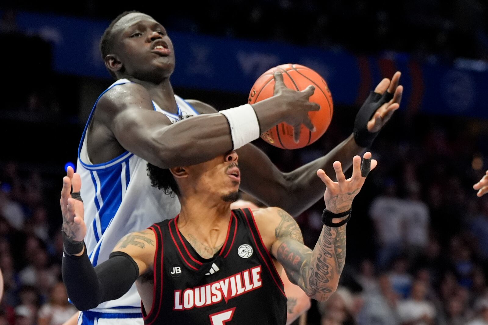 Duke center Khaman Maluach vies for the ball with Louisville guard Terrence Edwards Jr. during the first half of an NCAA college basketball game in the championship of the Atlantic Coast Conference tournament, Saturday, March 15, 2025, in Charlotte, N.C. (AP Photo/Chris Carlson)