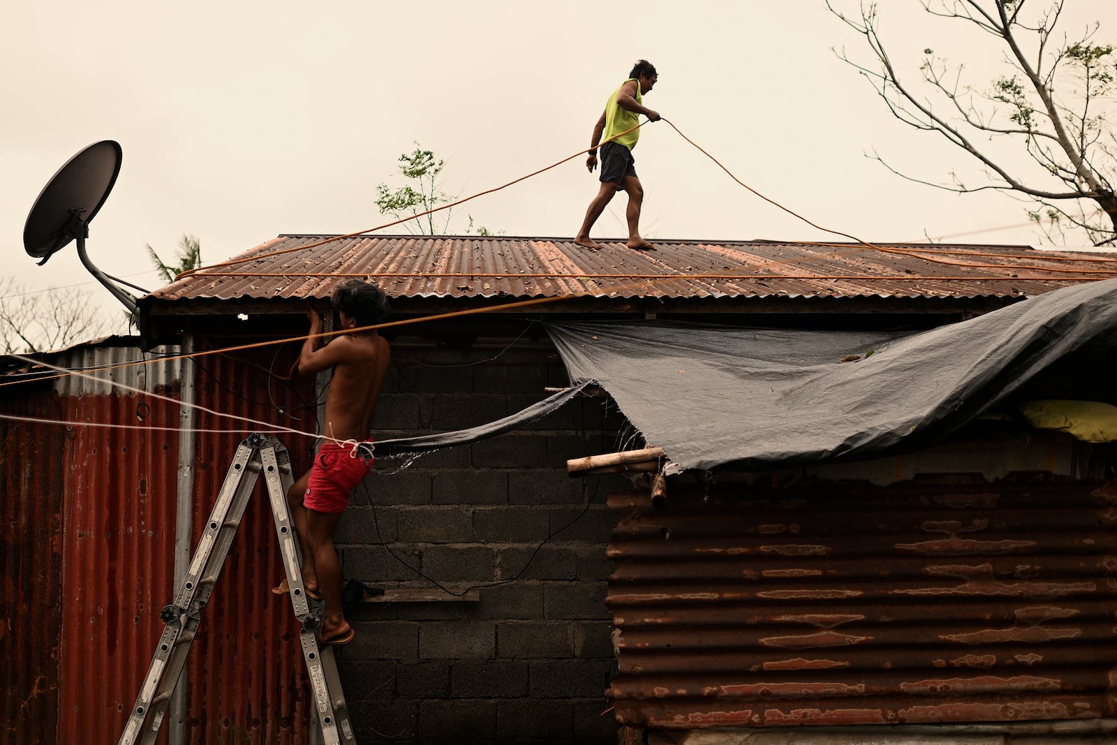 A resident reinforces his roof in Santa Ana, Cagayan Province, northern Philippines as they anticipate Typhoon Usagi to hit their area Thursday, Nov. 14, 2024. (AP Photo/Noel Celis)