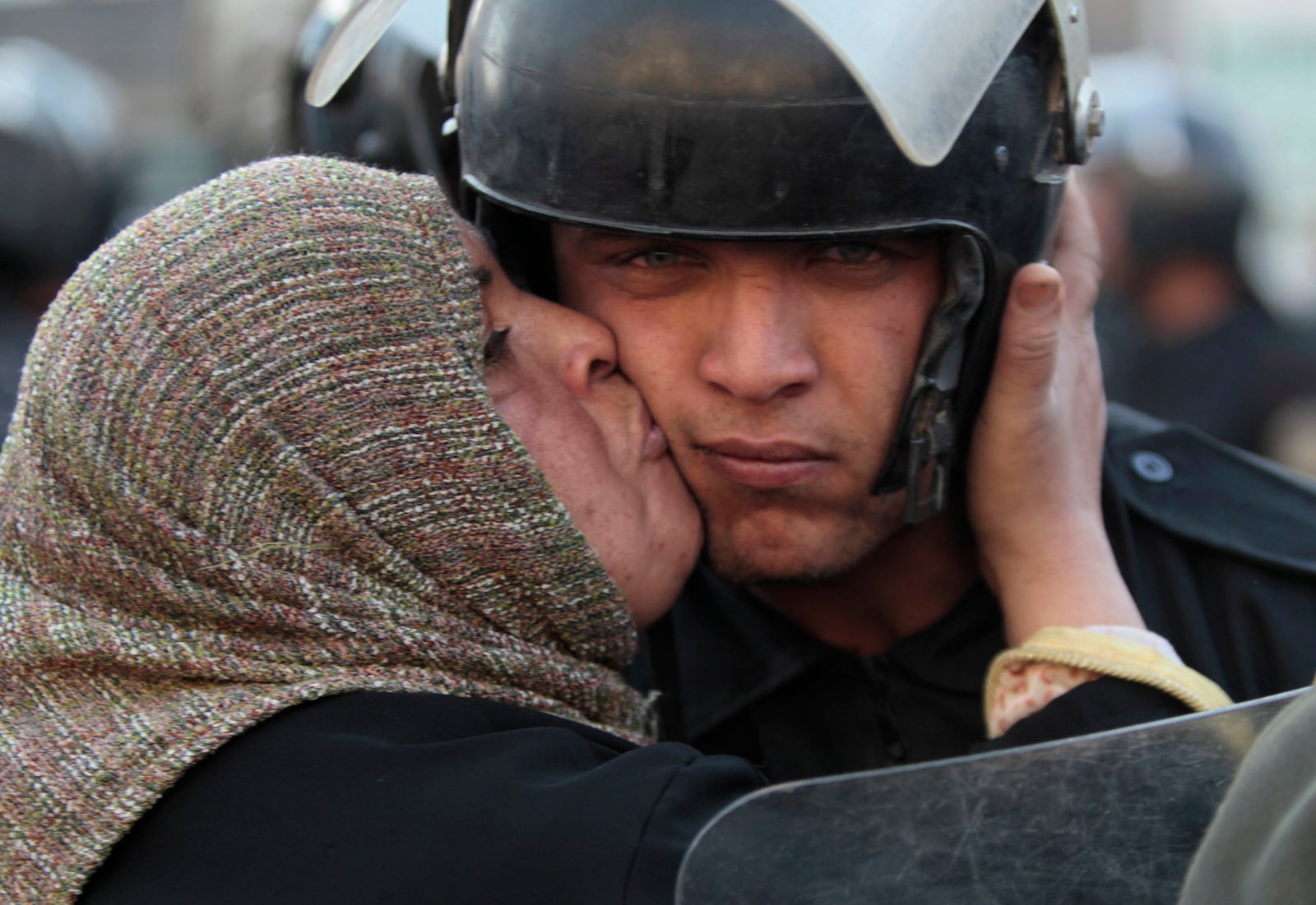 FILE - An Egyptian anti-government activist kisses a riot police officer following clashes in Cairo, Egypt, on Jan. 28, 2011. (AP Photo/Lefteris Pitarakis, File)