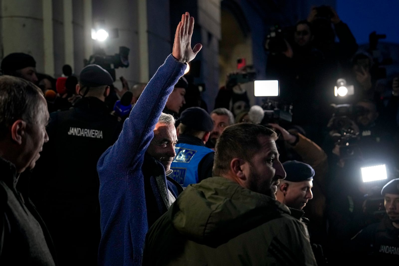 Calin Georgescu, the winner of Romania's first round of presidential election, annulled by the Constitutional Court, waves to supporters as he leaves the prosecutors office after being stopped in traffic and taken in for questioning in Bucharest, Romania, Wednesday, Feb. 26, 2025. (AP Photo/Vadim Ghirda)