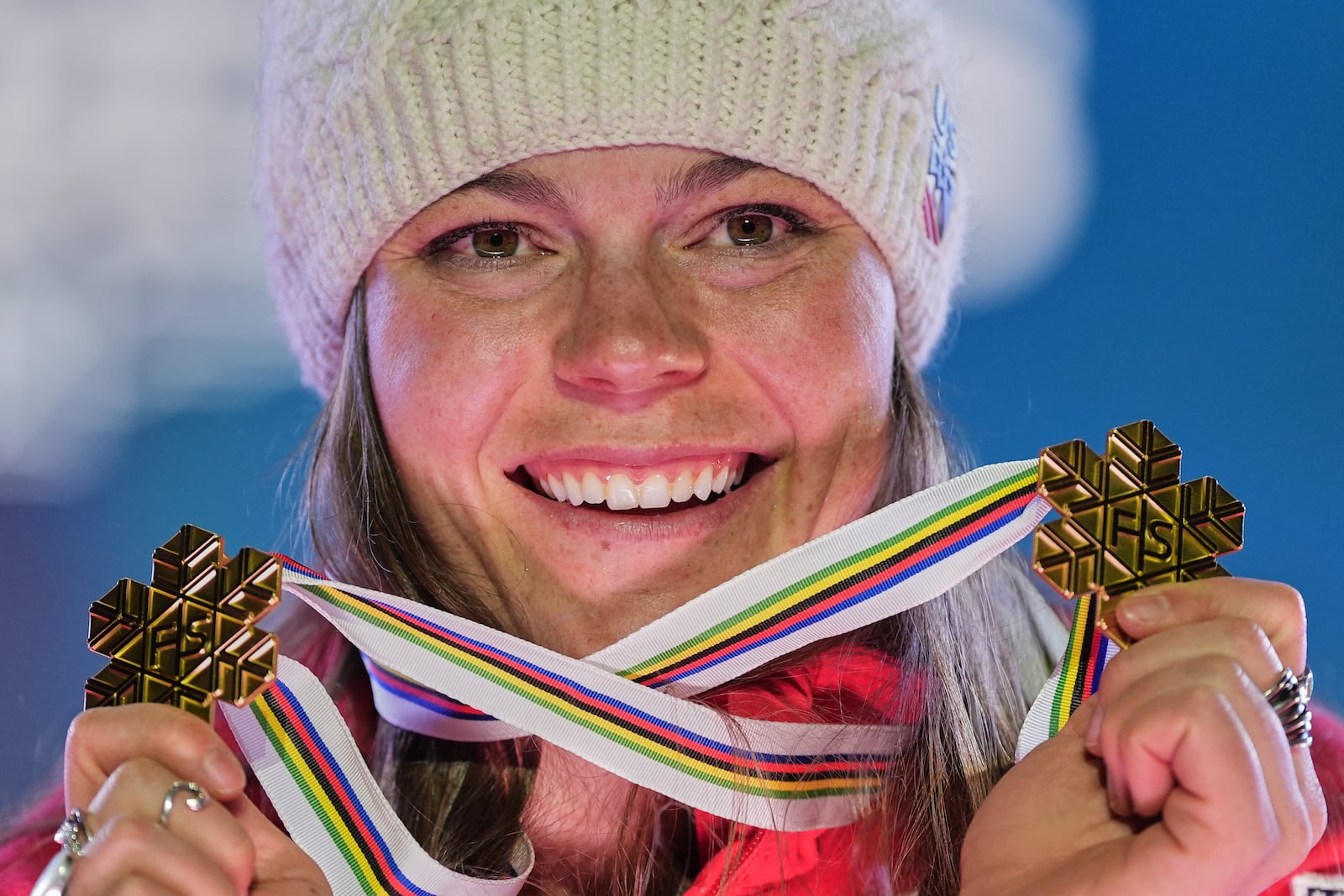 United States' Breezy Johnson shows her gold medal for a women's downhill and for a women's team combined event, at the Alpine Ski World Championships, in Saalbach-Hinterglemm, Austria, Tuesday, Feb. 11, 2025. (AP Photo/Giovanni Auletta)