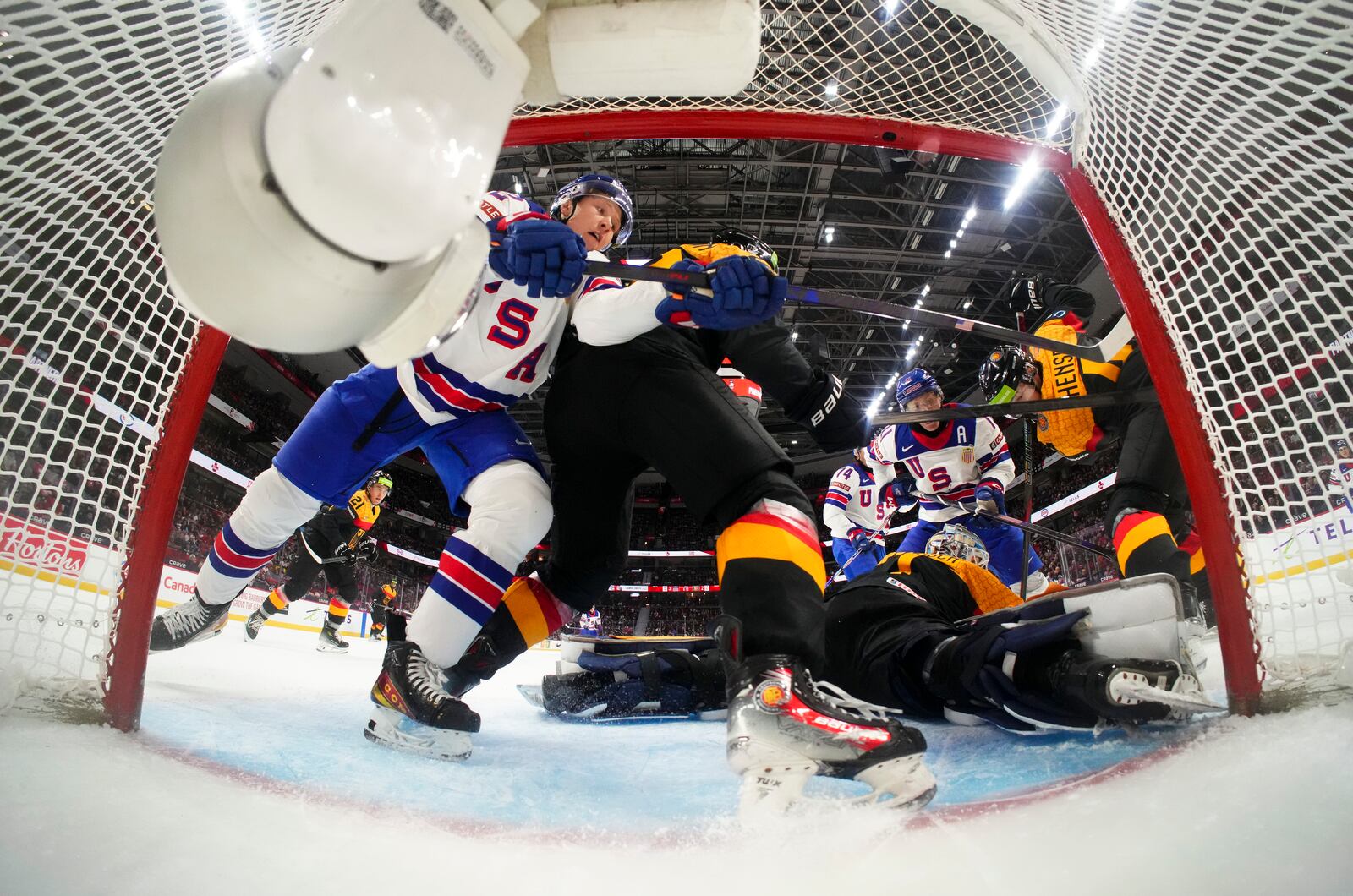 Germany goaltender Nico Pertuch, bottom right, defends his net as a United States player battles for the puck during second-period IIHF World Junior Hockey Championship preliminary round game action in Ottawa, Ontario, Thursday, Dec. 26, 2024. (Sean Kilpatrick/The Canadian Press via AP)